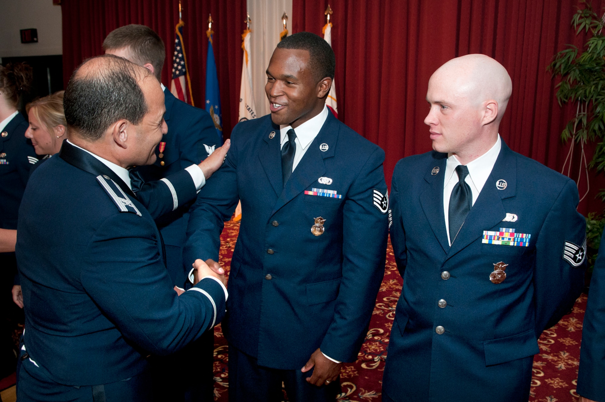HANSCOM AIR FORCE BASE, Mass. – Col. Juan Gaud (left), 66th Air Base Group deputy commander, congratulates Airman Leadership School Class 12E graduate Staff Sgt. Phillip Prather Jr., 66th Security Forces Squadron, during a ceremony at the Minuteman Commons Aug. 10 as Staff Sgt. Kyle Williams, 66th Security Forces Squadron, looks on. ALS graduation marks an important step in enlisted professional military education. (U.S. Air Force photo by Mark Wyatt)
