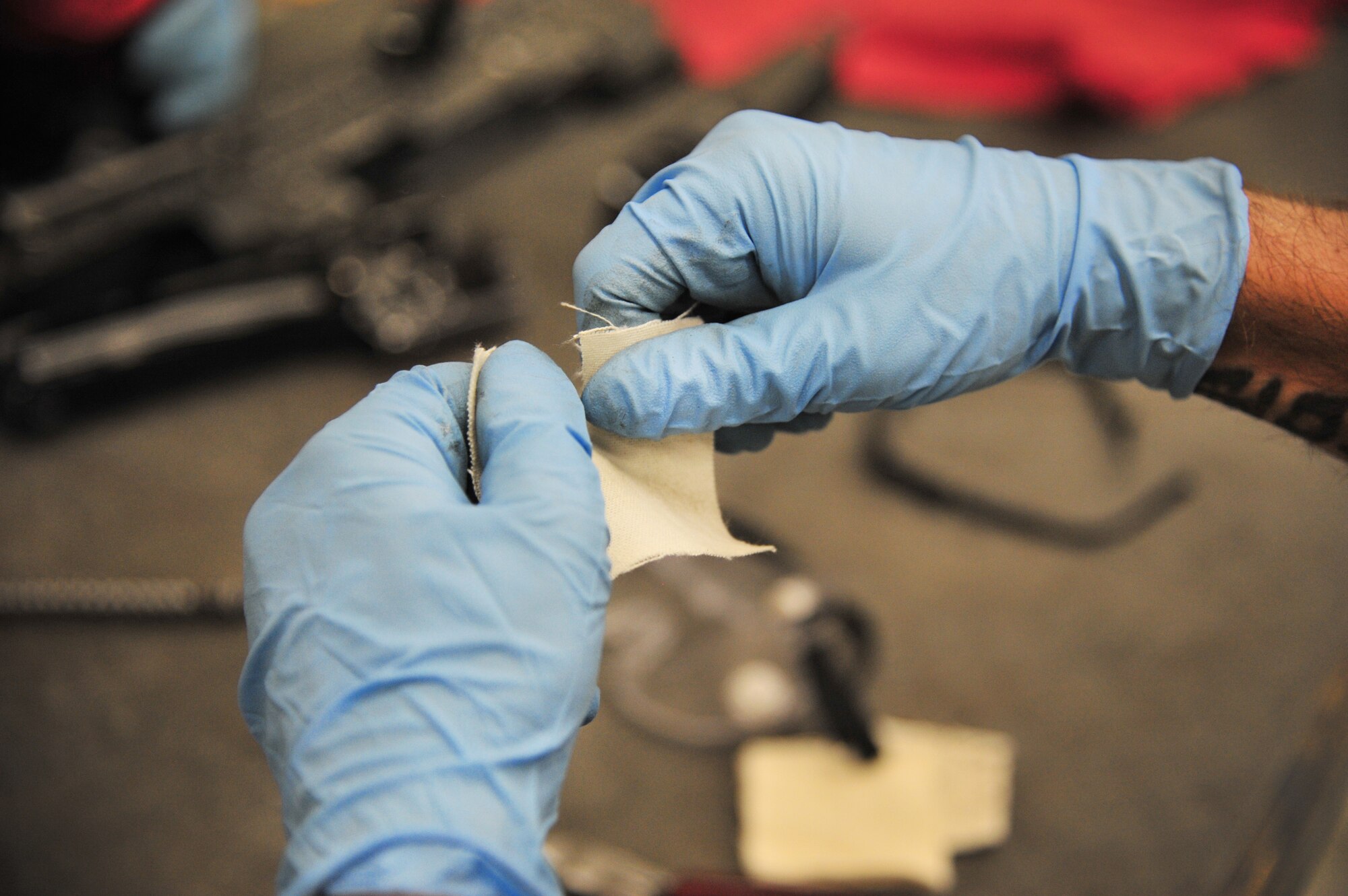 U.S. Air Force Senior Airman Ricky Franklin, 27th Special Operations Maintenance Squadron, rips small cloth squares used to clean weapons in the armament shop at Cannon Air Force Base, N.M., Aug. 14, 2012. Armament troops handle disassembling, cleaning, lubing and inspecting weaponry for their assigned aircraft at Cannon. (U.S. Air Force photo/Airman 1st Class Alexxis Pons Abascal)  