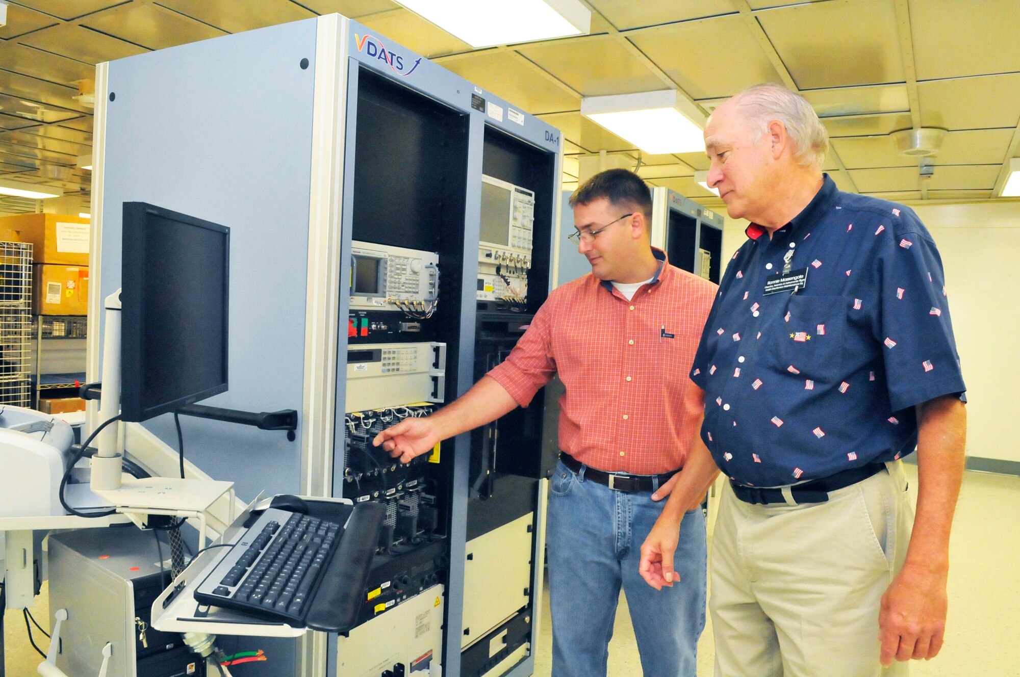 Jeff Lamb, element chief and Robbie Massengale, Avionics and Instruments Flight director, discuss the Versatile Depot Automatic Test Stations (VDATS) that will be utilized for the new LAIRCM work. Eventually around 15,000 square-feet will be devoted to the new workload. Northrop Grumman Technical Services (NGTS) was recently awarded a $485 million contract to repair the Large Aircraft Infrared Countermeasures (LAIRCM) System.  (U. S. Air Force photo/ Sue Sapp)