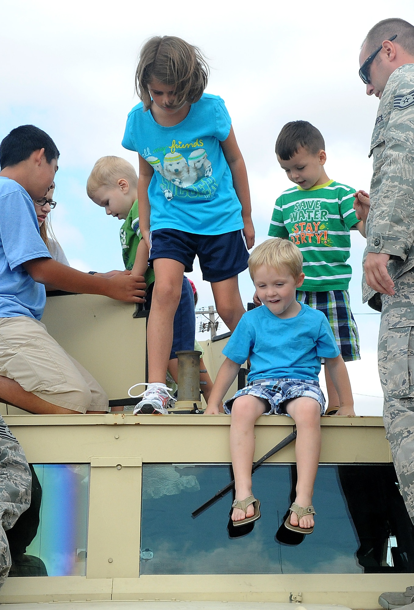 Children explore and play on top of a humvee Aug 10 at Scott Air Force Base, Ill. The 375th Civil Engineer Squadron hosted a bring your kids to work day and brought out equipment and vehicles for the children and parents to look at, as well as play with. (U.S. Air Force photo/Amn Kristina Lynch)