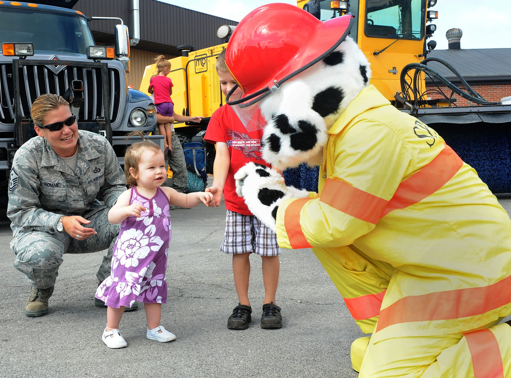 Kylie, 1, says hello to Sparky, the 375th Civil Engineer Squadron fire dog Aug 10 at Scott Air Force Base, Ill. Whenever CE hosts a family event involving children, Sparky comes out to say hello and play with the children. (U.S. Air Force photo/Amn Kristina Lynch)