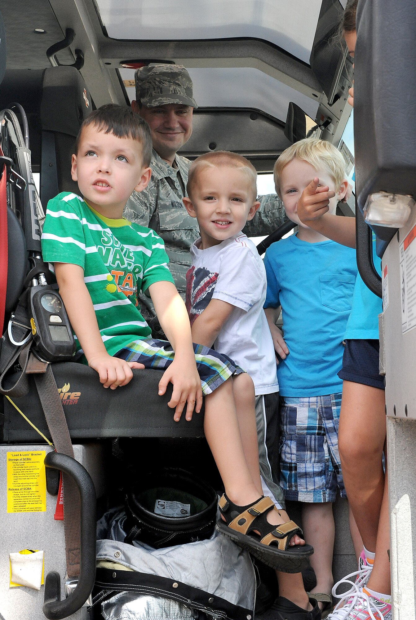 Children play around inside of a fire truck Aug 10 at Scott Air Force Base, Ill. Master Sgt. Jennifer Roman, 375th Civil Engineer Squadron first sergeant, and Mrs. Megan Schuliger, key spouse and wife of Lt. Col. John Schuliger, 375th Civil Engineer Squadron commander, organized the event where CE members brought their spouses and children to the CE compound for them to see and play with some of the equipment used in order for them to do their jobs. (U.S. Air Force photo/Amn Kristina Lynch)