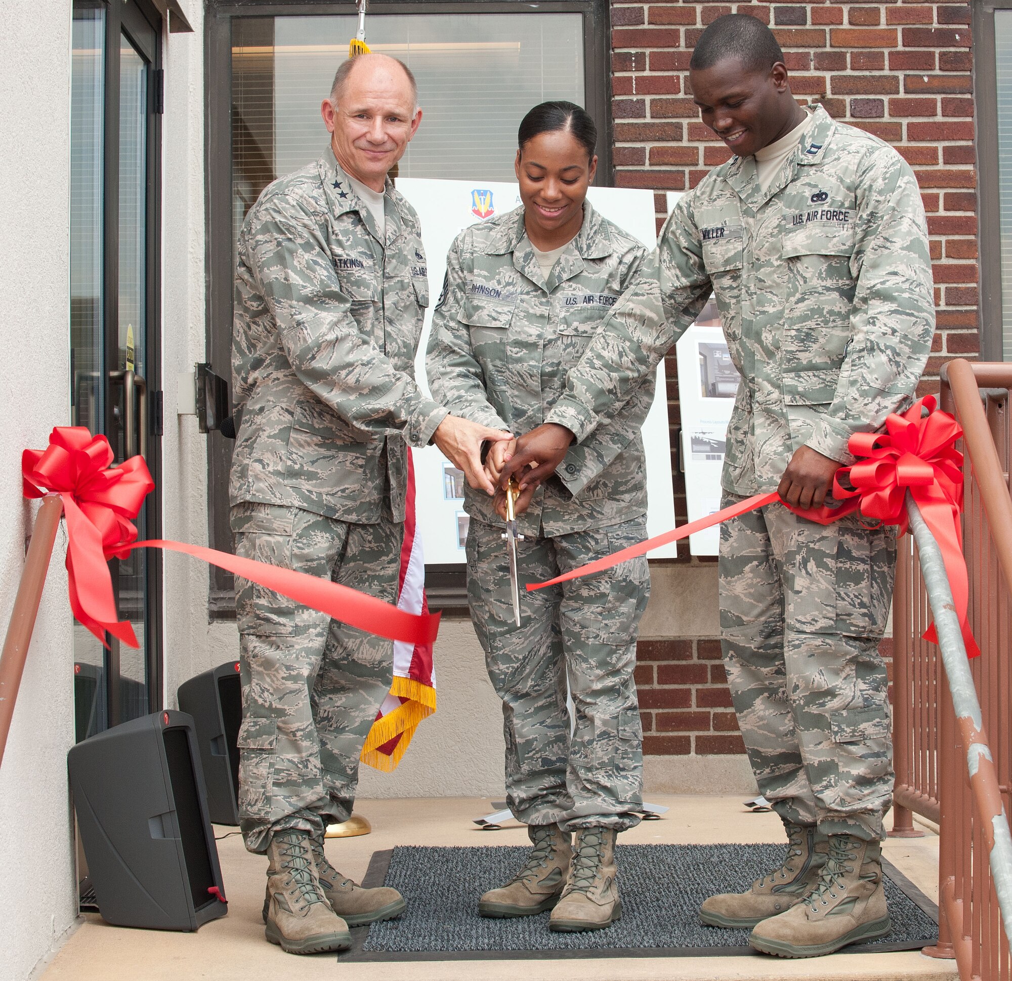 From left, U.S. Air Force Maj. Gen. Mark Atkinson, Air Combat Command Logistics director, U.S. Air Force Staff Sgt. Lasheena Johnson, ACC Logistics Readiness Division logistics detail manager, and U.S. Air Force Capt. Lyndel Miller, ACC Logistics Readiness Division command transportation functional manager, cut a ribbon commemorating the opening of their new heritage room at Langley Air Force Base, Va., Aug. 10, 2012. The room features photographs and artwork illustrating Air Force logistics through the ages. (U.S. Air Force photo by Tech. Sgt. Barry Loo/Released)
