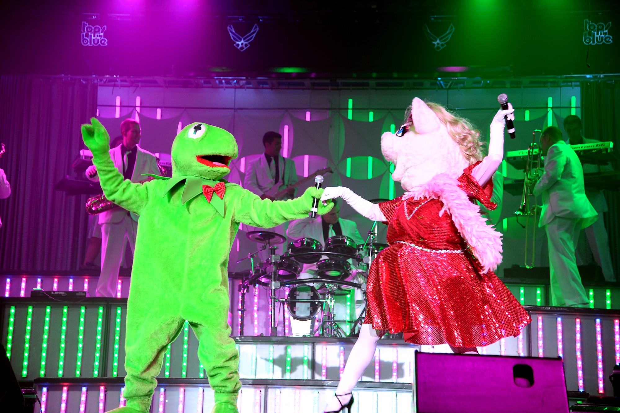 Two Tops in Blue performers put on costumes of Kermit the Frog and Miss Piggy as they sang to entertain the audience of the Columbus Air Force Base stop on the Tops in Blue “Listen!” 2012 World Tour Aug. 11.  The Tops in Blue performances are obligated to master specific instrumental, vocal, choreography and staging requirements in addition to the technical skills required to become their own road crew.  (U.S. Air Force Photo/Airman 1st Class Charles Dickens) 