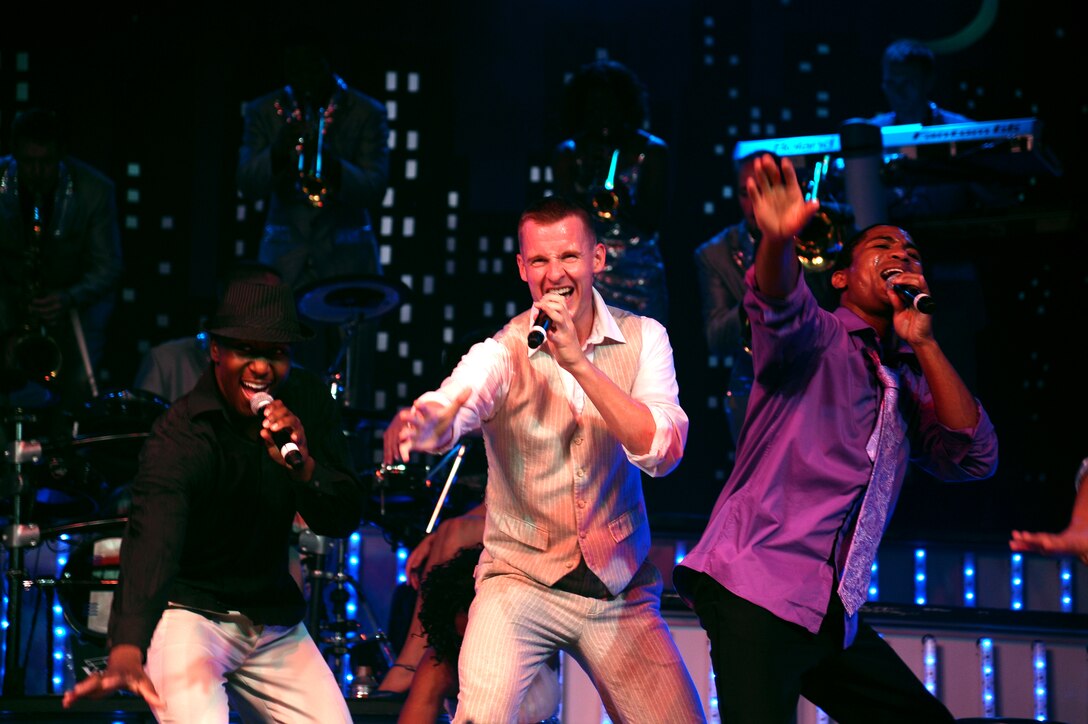 Airman 1st Class Jonathan Leak, 2nd Lt. Joseph Mitchell and Senior Airman Charles Cooper, vocalists of Tops in Blue 2012, perform a song and dance routine during the Tops in Blue “Listen!” 2012 World Tour in Columbus, Miss. Aug. 11.  Tops in Blue travels to military installations around the world to bring merriment to service and community members.  (U.S. Air Force Photo/Airman 1st Class Charles Dickens)