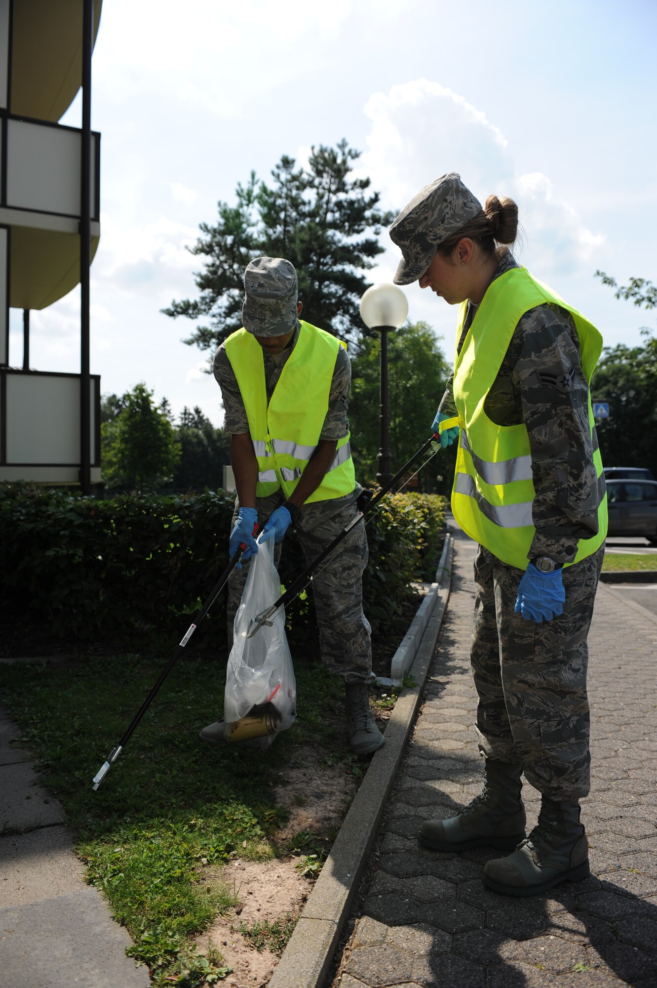 SPANGDAHLEM AIR BASE, Germany – Airman 1st Class Baylie Robbins, right, 52nd Logistics Readiness Squadron Eifel Pride volunteer, and Airman 1st Class David Kelly, 52nd Security Forces Eifel Pride volunteer, clean up trash around a temporary lodging facility here Aug. 13. First-term Airmen make up Eifel Pride, a clean-up group that picks up trash and debris caused by storms and wind on base. Cleaning the base ensures it is visually appealing for base members, visitors and the local community. (U.S. Air Force photo by Senior Airman Natasha Stannard/Released)

