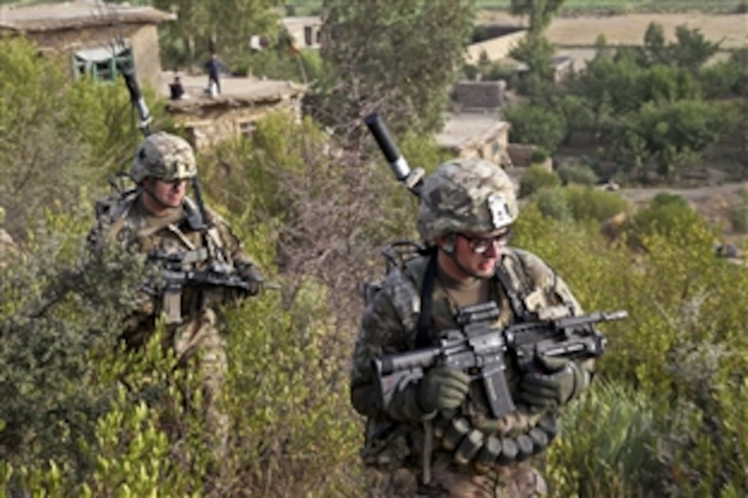 U.S. Army Spc. Timothy Rigg and U.S. Army Staff Sgt. Jon Phillips patrol through Black Rock in Khost province, Afghanistan, July 31, 2012.