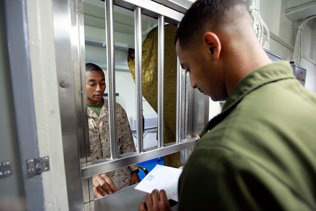 Lance Cpl. Freddie Richardson, disbursing clerk, 15th Marine Expeditionary Unit, assists Sgt. Mohamed R. Muhidin, night crew supervisor, Marine Medium Helicopter Squadron 364, 15th MEU, set up his Marine Cash card, July 29. The Disbursing Office assists Marines and sailors of the MEU by replacing cash with Marine Cash cards to make purchases while embarked on ships in the Peleliu Amphibious Ready Group. However, they do much more than that. Their mission is to provide deployed disbursing support to the troops to ensure they are properly paid and resolve any pay and entitlement problems they may incur. Richardson, 22, is from Fredricksberg, Va.