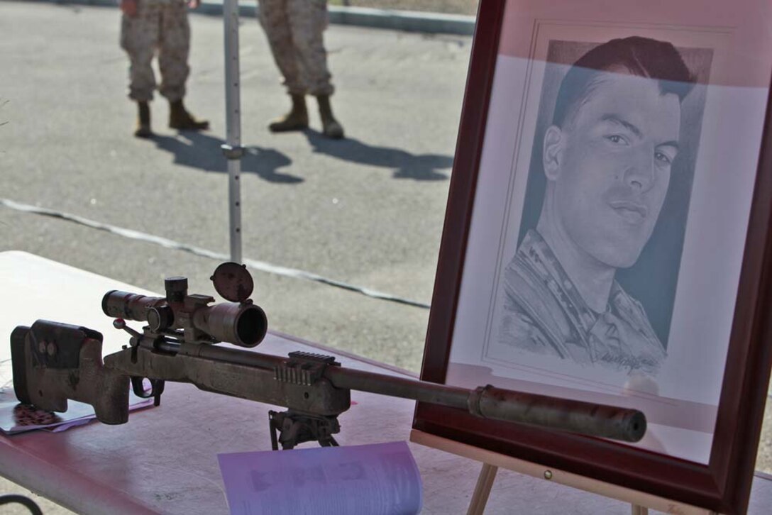 Sergeant Matthew T. Abbateâ€™s sniper rifle sits in front of a sketch of him during a Navy Cross award ceremony at Camp Pendleton, Calif., Aug. 10. Abbate was posthumously awarded the medal for the actions he took on Oct. 14, 2010 in Sangin, Afghanistan during his deployment with Company K, 3rd Battalion, 5th Marines, 1st Marine Division. Abbate was killed in action in Helmand Province later that year.