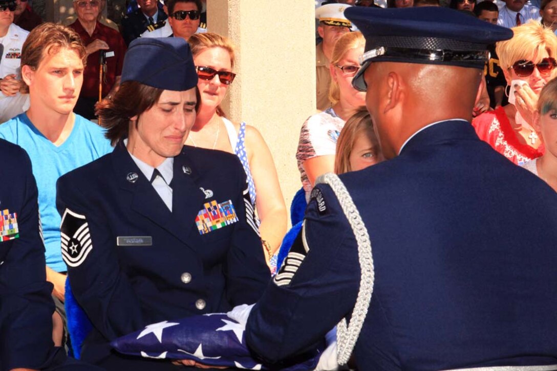 Air Force Master Sgt. Laurice Souron, training manager with 163rd Reconnaissance Wing, accepts the U.S. flag from the honor guard during a memorial for her mother, Laura Froehlich, at the Riverside National Cemetery Aug. 10. For more than 10 years, when the nation called for Marines and sailors to depart March Air Reserve Base to deploy to Iraq and Afghanistan in support of Operation Iraqi Freedom and Operation Enduring Freedom, she was on call to say goodbye and greet them upon return.