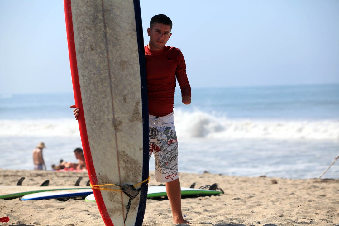 Wounded Warrior, Sgt. Michael Spivey, a combat engineer with 1st Combat Engineer Battalion, stands with his surfboard, waiting for another participant, before attacking the Pacific Ocean waves during a three-day surf camp at Camp Pendleton's San Onofre Beach, Aug. 12. Operation Amped held the sport therapy camp to provide surfing lessons to rehabilitating injured service members and their families.