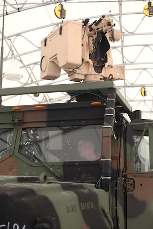 Lance Cpl. Dominick W. Phillips (inside cab), a field radio operator with Combat Logistics Regiment 2, 2nd Marine Logistics Group, observes as two Marines operate a Gunslinger Package for Advanced Convoy Security system aboard Camp Lejeune, N.C., Aug. 15, 2012.  The GPACS system provides easy communication between machine gunners, better weapon control and can be mounted on a Medium Tactical Vehicle Replacement. The system is equipped with night vision and thermal capabilities, and is designed to carry the M249 light machine gun, M240 medium machine gun, or Mark II .50 caliber machine gun.