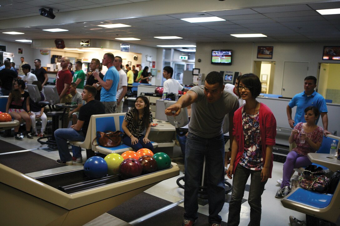 Lance Cpl. Jorge A. Maldonado advises Chie Torikai where to throw a strike at a cultural exchange event held by the single Marine program at the Futenma Bowling Center at Marine Corps Air Station Futenma Aug. 8. The event provided service members and Japanese college students the chance to build confidence in their communication, and start new friendships. Maldonado is an aviation supply specialist with Marine Aviation Logistics Squadron 36, Marine Aircraft Group 36, 1st Marine Aircraft Wing, III Marine Expeditionary Force and Torikai is a student at Naha Nikkei College of Business. 