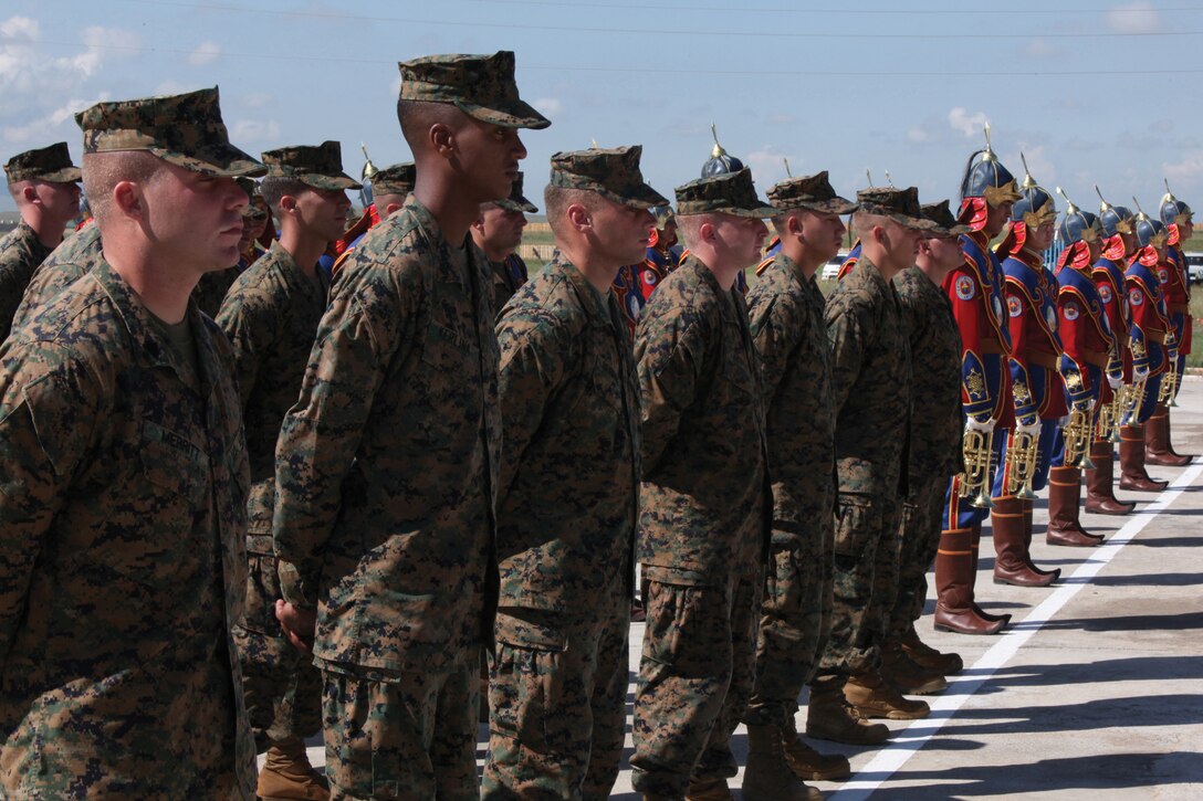 U.S. Marines stand in formation next to the Mongolian Armed Forces band during the opening ceremony for Khaan Quest 2012 at the Five Hills Training Area near Ulaanbaatar, Mongolia, Aug. 12. The multinational exercise focuses on training service members from more than 10 nations in peacekeeping operations and is co-sponsored by U.S. Army Pacific and the Mongolian Armed Forces. The Marines are with Company E, 2nd Battalion, 3rd Marine Regiment, 3rd Marine Division, III Marine Expeditionary Force. 