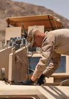 Cpl. Adam R. Tornatore examines the engine of a mine-resistant ambush-protected vehicle at Forward Operating Base Zebrugge, Helmand province, Afghanistan, July 11. The vehicle suffered engine problems during the patrol, and it needed to be recovered on site.