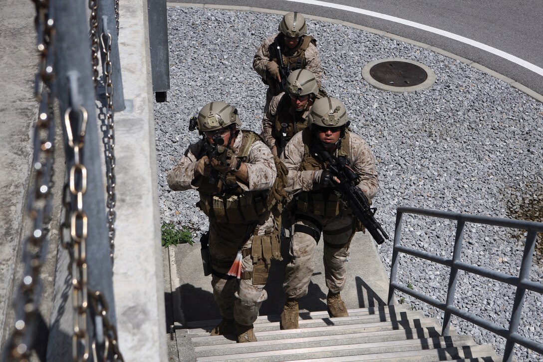 Marines ascend stairs with unloaded weapons at the close-quarters battle facility at Camp Hansen Aug. 11. The Marines trained at range 17B to increase their close-quarters battle skills. The Marines are with Fleet Anti-Terrorism Security Team Company Pacific, 7th Fleet, is based out of Yokosuka Naval Base, Japan.
