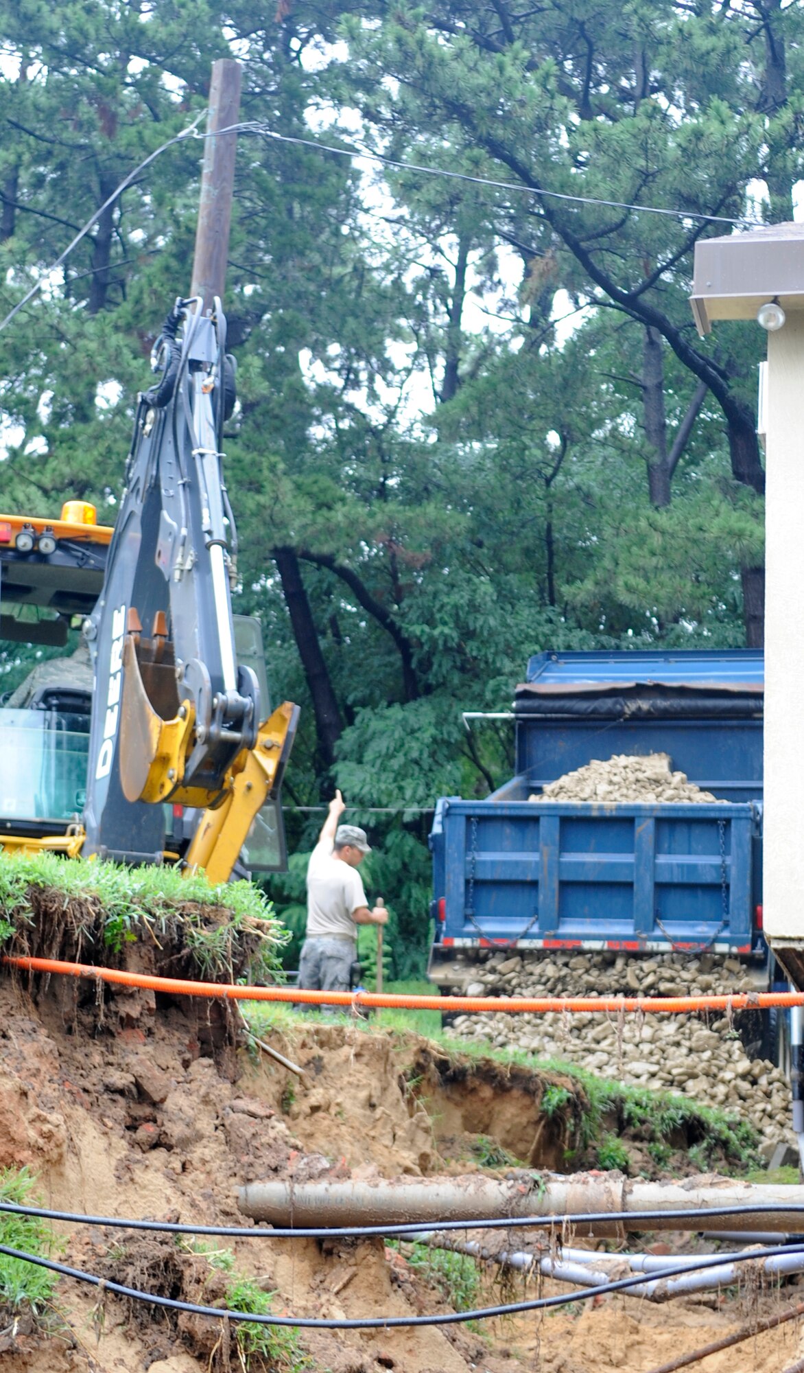 Members of the 8th Civil Engineer Squadron fill in a large hole caused by water runoff after heavy rains at Kunsan Air Base, Republic of Korea, Aug. 13, 2012. Overnight, more than 11 inches of rain fell and caused major flooding on the base. (U.S. Air Force photo/Senior Airman Brigitte N. Brantley)