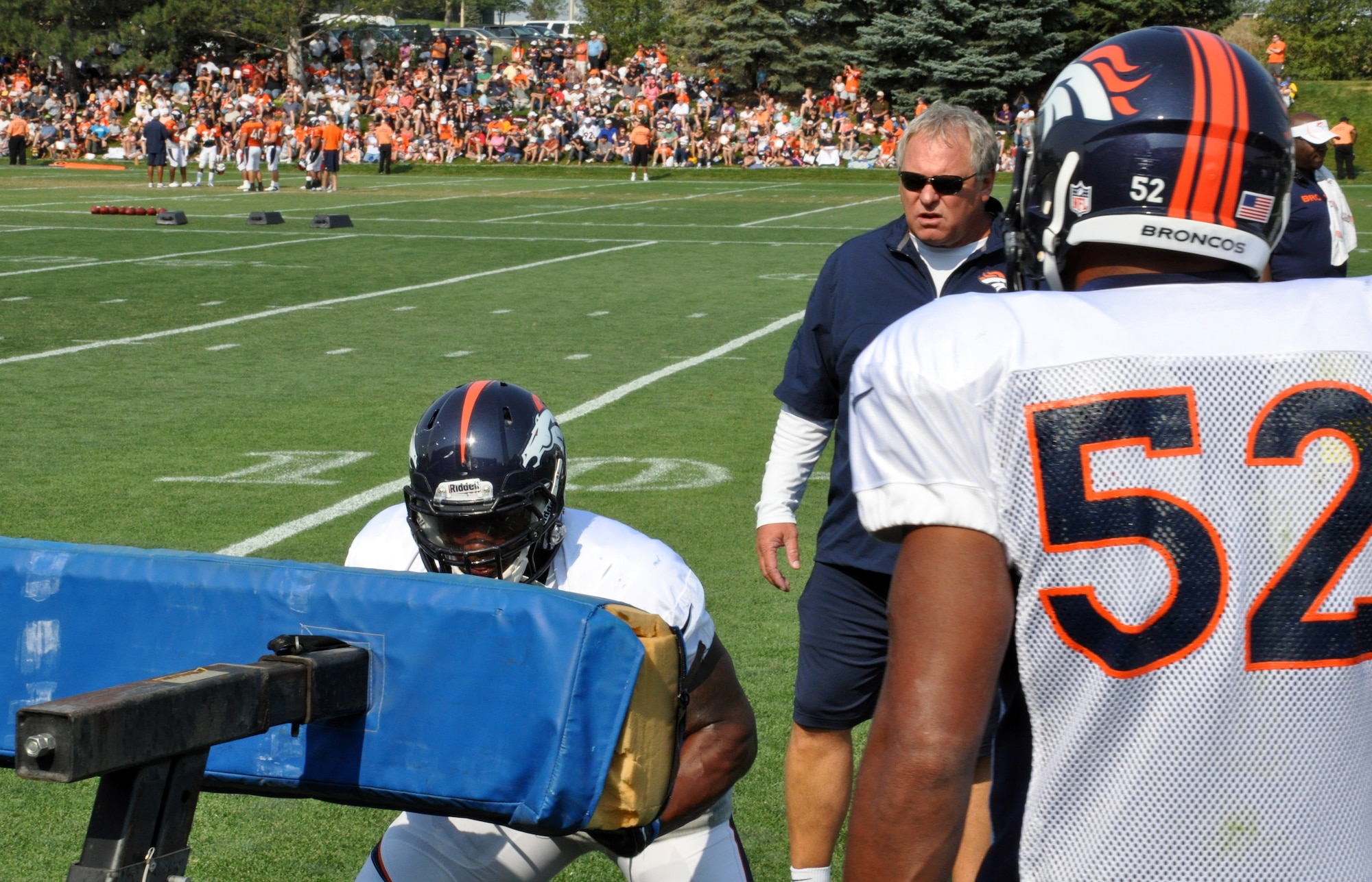 ENGLEWOOD, Colo. – Wesley Woodyard, special team’s captain and weak outside linebacker, watches as one of his teammates hits the “sled” during training camp Aug. 14, 2012 at the Broncos training facility. The best advice Benjamin Garland, Broncos defensive end, said he’s received during training camp has been from Woodyard. Who told him to continue to work as hard as he has been and to keep pushing it to that next level every time he steps out on the field. Garland is also a lieutenant with the 140th Wing Public Affairs, Buckley Air Force Base. (U.S. Air Force photo by Staff Sgt. Nicholas Rau)