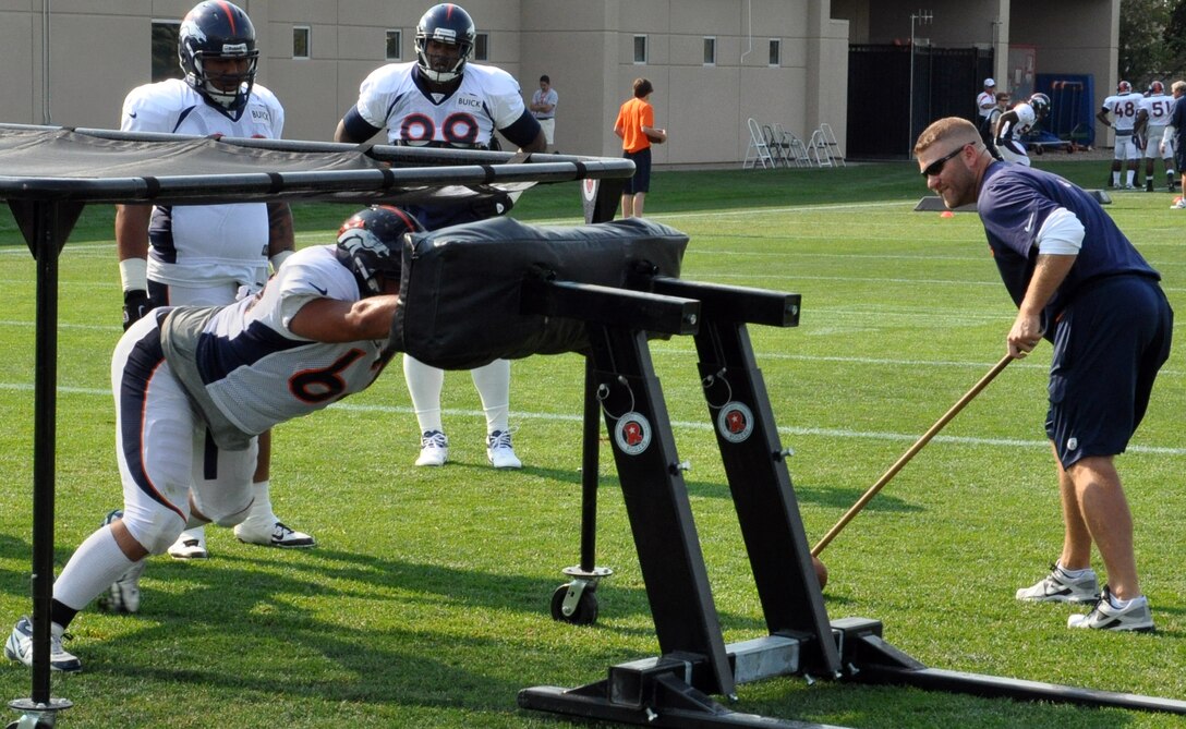 ENGLEWOOD, Colo. – Benjamin Garland, Denver Broncos defensive end, hits the “sled” during training camp Aug. 14, 2012 at the Broncos training facility. Garland is also a lieutenant with the 140th Wing Public Affairs, Buckley Air Force Base. (U.S. Air Force photo by Staff Sgt. Nicholas Rau)