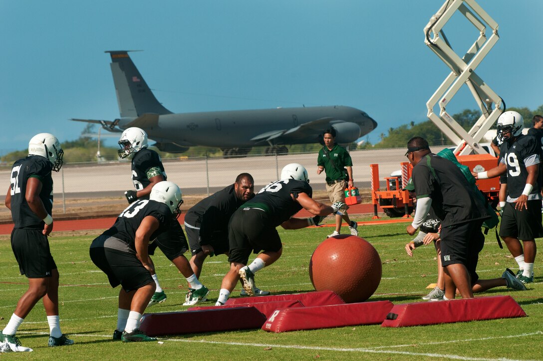 University of Hawaii football players run drills during the Warriors practice at Joint Base Pearl Harbor-Hickam Aug. 13. Due to the UH dormitories being cleaned and prepared for the start of the fall season, the Warriors had to seek accommodations elsewhere to continue their training camp. The UH football team is scheduled to be on the road for their opener Sept. 1, in Los Angeles, against the University of Southern California Trojans. (U.S. Air Force photo/Staff Sgt. Mike Meares)