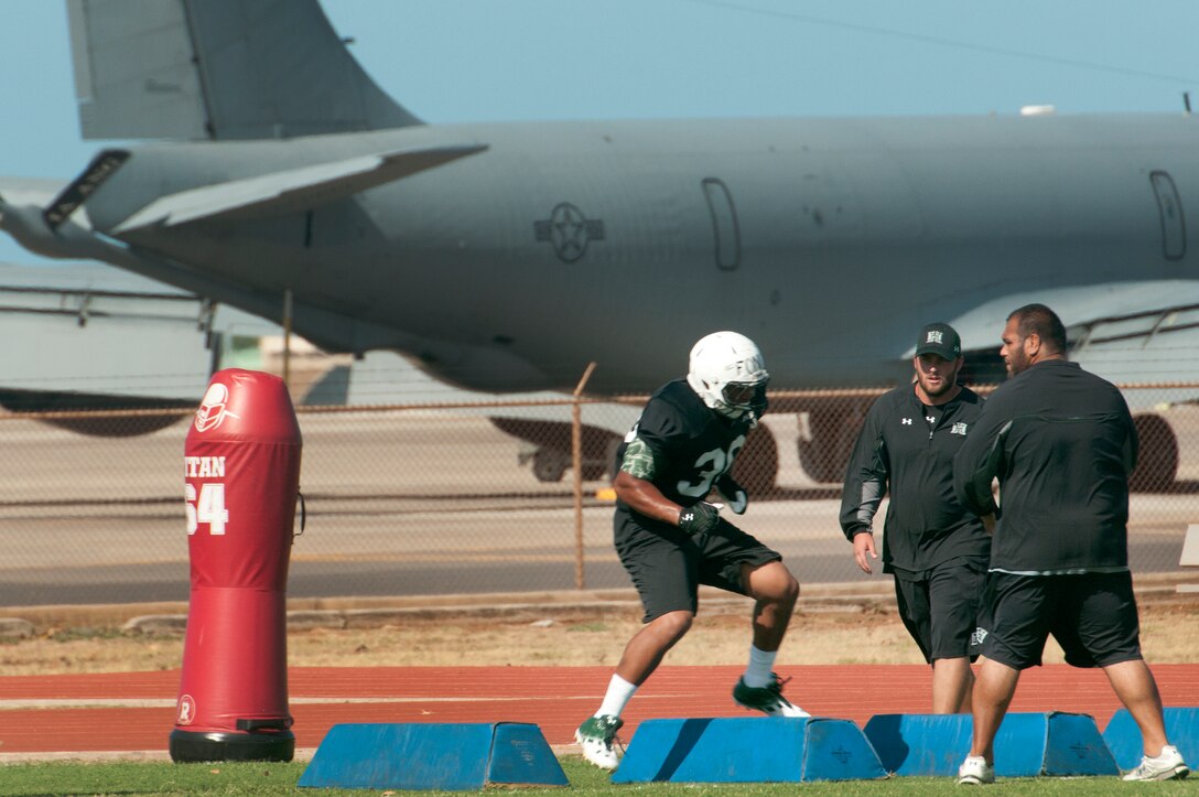 University of Hawaii football players run drills during the Warriors practice at Joint Base Pearl Harbor-Hickam Aug. 13. Due to the UH dormitories being cleaned and prepared for the start of the fall season, the Warriors had to seek accommodations elsewhere to continue their training camp. The UH football team is scheduled to be on the road for their opener Sept. 1, in Los Angeles, against the University of Southern California Trojans. (U.S. Air Force photo/Staff Sgt. Mike Meares)