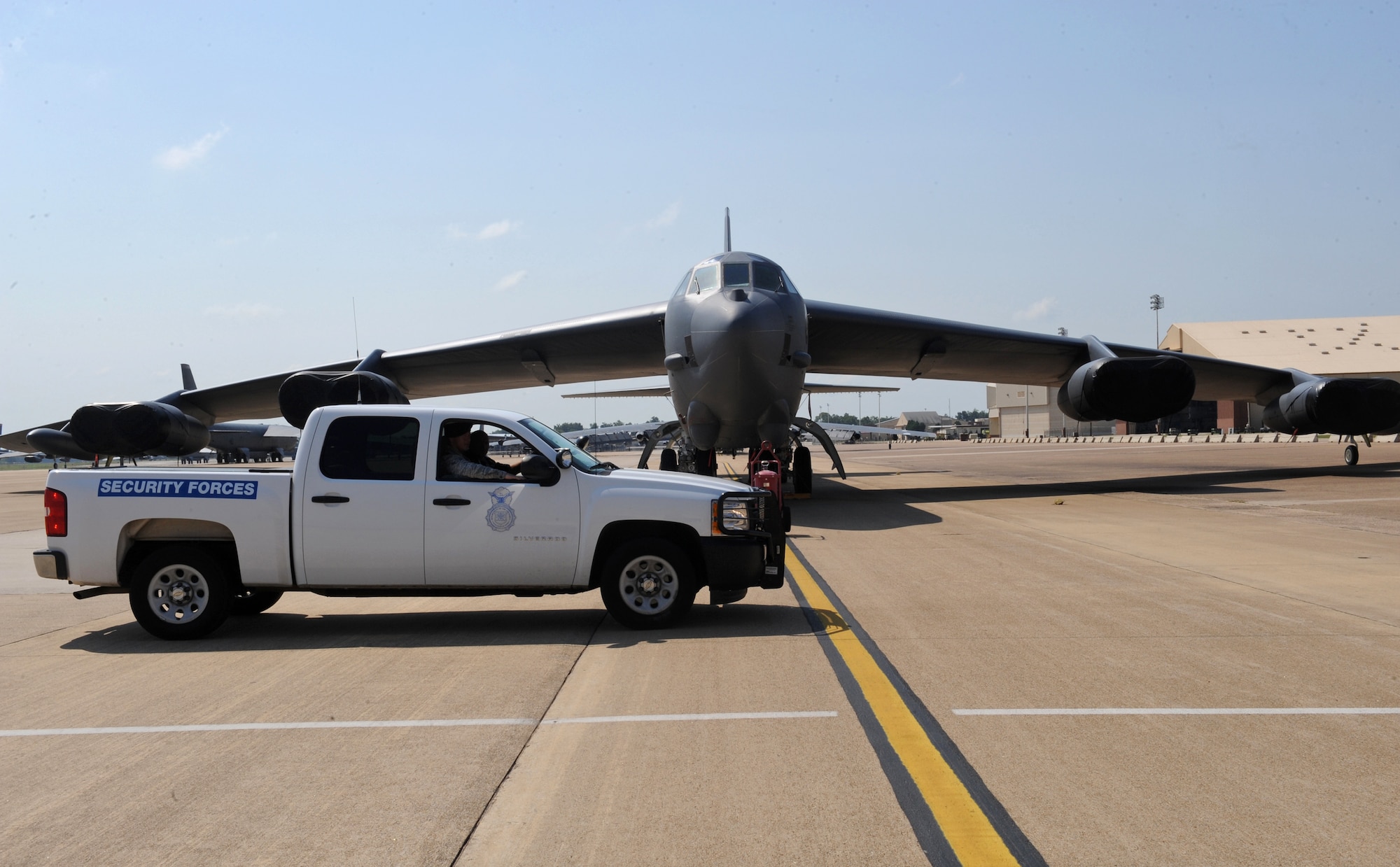 A 2nd Security Forces Squadron truck patrols near a B-52H Stratofortress on Barksdale Air Force Base, La., Aug. 10. When patrolling the flightline, 2 SFS Airmen ensure no one is tampering with the aircraft. They also ensure that personnel with restricted area access have their credentials and that visitors are being properly escorted. (U.S. Air Force photo/Airman 1st Class Benjamin Gonsier)(RELEASED)