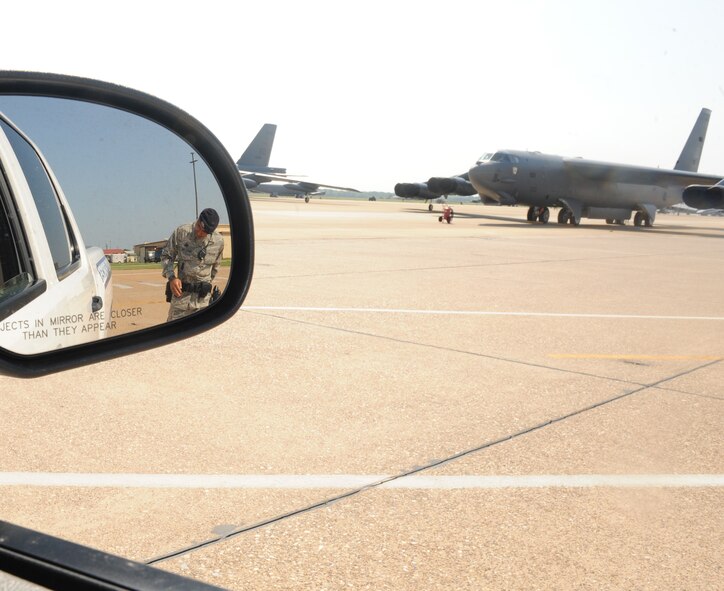 Master Sgt. Andre McBride, 2nd Security Forces Squadron flight chief, performs a foreign object debris walk prior to entering the flightline on Barksdale Air Force Base, La., Aug. 10. A FOD walk is performed every time a vehicle enters an entry control point on the flightline. FOD on the flightline can be a hazard to aircraft because it can be sucked into the engine and cause damage. (U.S. Air Force photo/Airman 1st Class Benjamin Gonsier)(RELEASED)