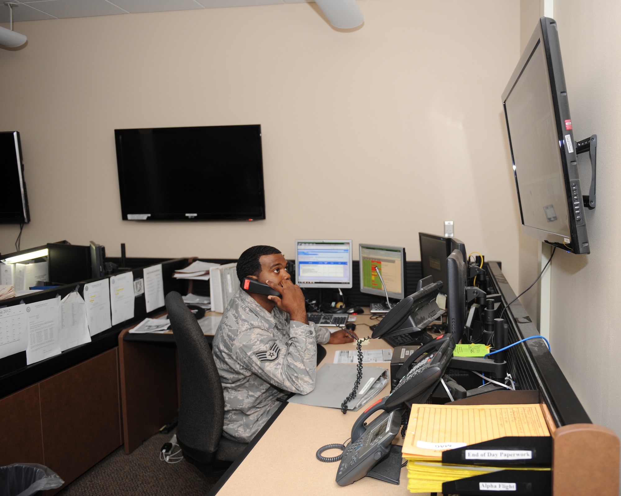 Staff Sgt. Vernard Warner, 2nd Security Forces Squadron, talks on the phone while watching surveillance video at the 2 SFS complex on Barksdale Air Force Base, La., Aug. 10. The 2 SFS monitors all of the gates on base as well as the entrances to the flightline to ensure there are no unauthorized entrances. If someone were to breach the base or flightline perimeter, the 2 SFS would alert the Airmen on patrol. (U.S. Air Force photo/Airman 1st Class Benjamin Gonsier)(RELEASED)
