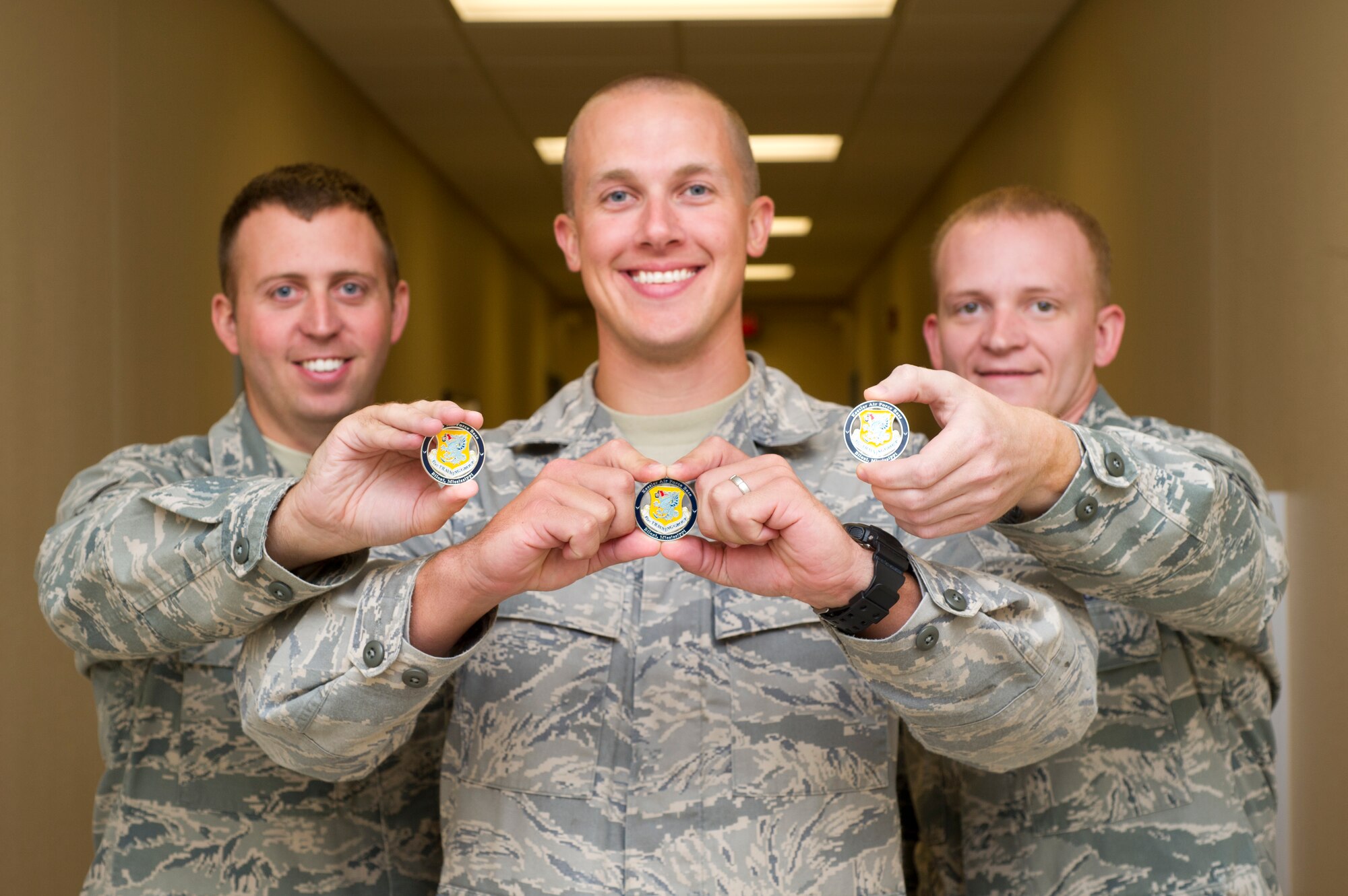 Airman 1st Class Kelsey Nutt, Staff Sgts. Adam Garren and Kerry Barber display coins they received from Col. Maureen Smith, 81st Training Group commander, Aug. 8, 2012, at Cody Hall, Keesler Air Force Base, Miss., for their heroic act on-scene of a vehicle accident on Interstate 10, near Bagdad, Fla.  (U.S. Air Force photo by Adam Bond)