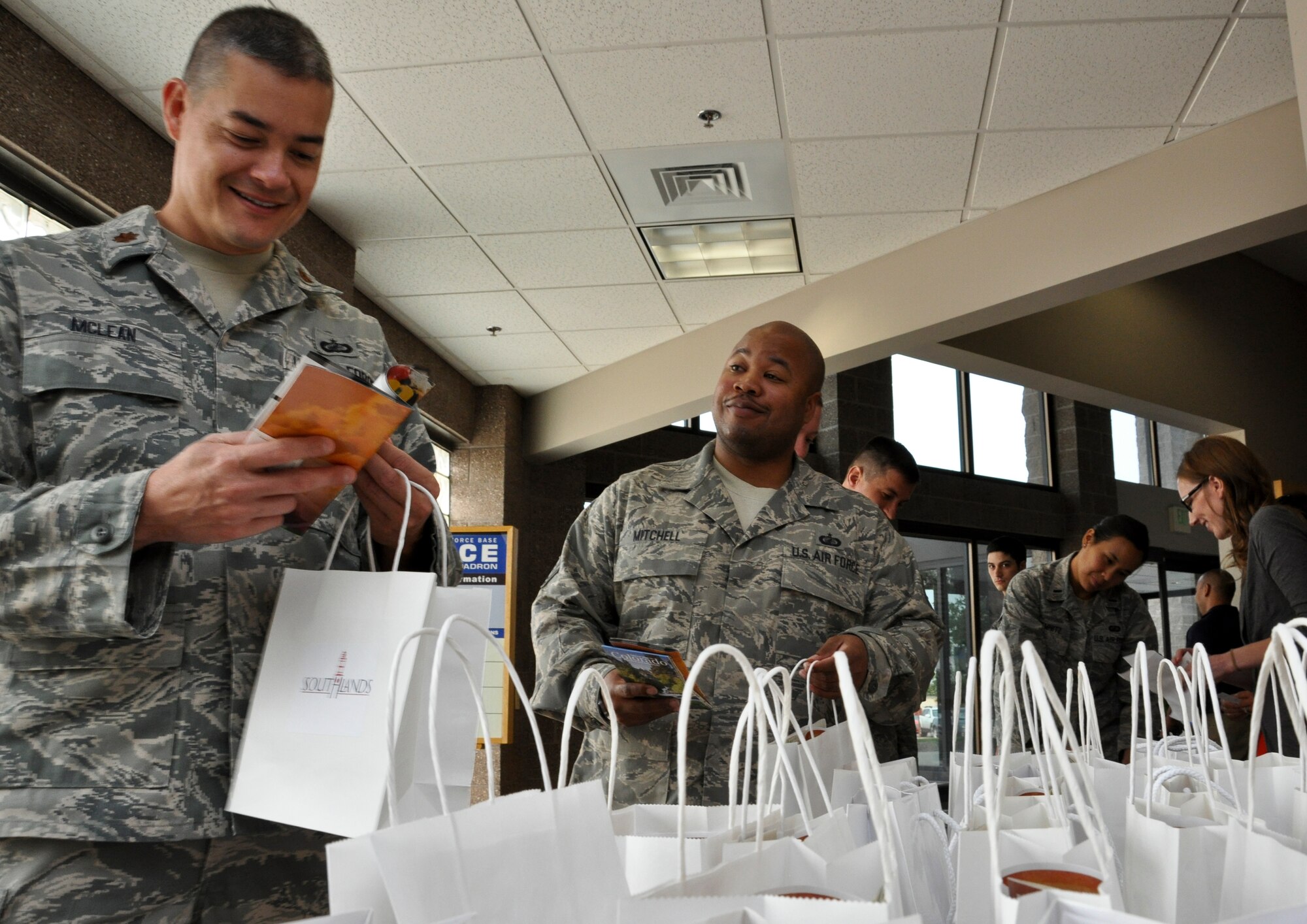 BUCKLEY AIR FORCE BASE, Colo. – Tech. Sgt. Jay Mitchell eyeballs Maj. Robert Mclean, both new arrivals to the Air Force Accounting and Finance Office, as he looks through his gift bag at the Buckley Newcomers Briefing Aug. 15, 2012.  The briefing brought in local community businesses and organizations to introduce themselves to the newest Team Buckley members.  (U.S. Air Force photo by Staff Sgt. Nicholas Rau)