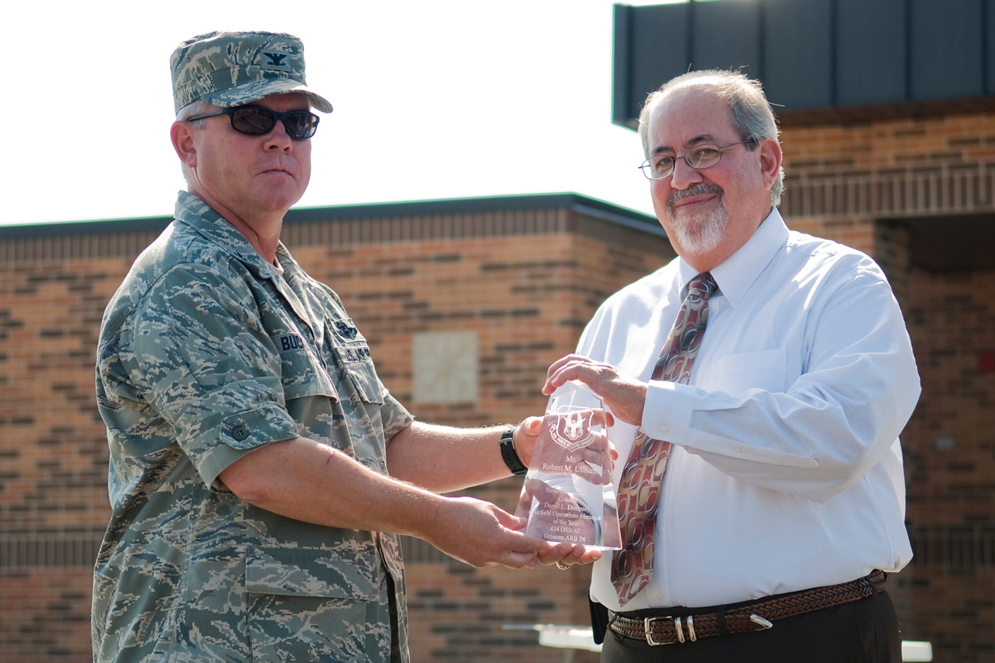 GRISSOM AIR RESERVE BASE, Ind. -- Col. Don Buckley, 434th Air Refueling Wing commander, presents Bob Ulibarri with an Air Force Reserve Command Col. Derrel L. Dempsey Airfield Operations Manager of the Year Award for 2011 during a ribbon cutting ceremony opening Grissom's new $7.4 million ATC tower Aug. 3. Ulibarri is a 434th Operations Support Squadron airfield operations manager. (U.S. Air Force photo/Tech. Sgt. Mark R. W. Orders-Woempner)