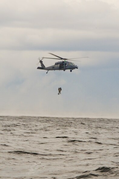 An HH-60 Pave Hawk with the 41st Rescue Squadron, Moody Air Force Base, Ga., hoists up two pararescuemen during water training in the Gulf of Mexico, Aug. 14, 2012. The Pave Hawk has multiple ways to retrieve personnel from the ground. The training allowed members to train on how to retrieve personnel located in open waters. (U.S. Air Force photo by Staff Sgt. Joshua J. Garcia/Released)