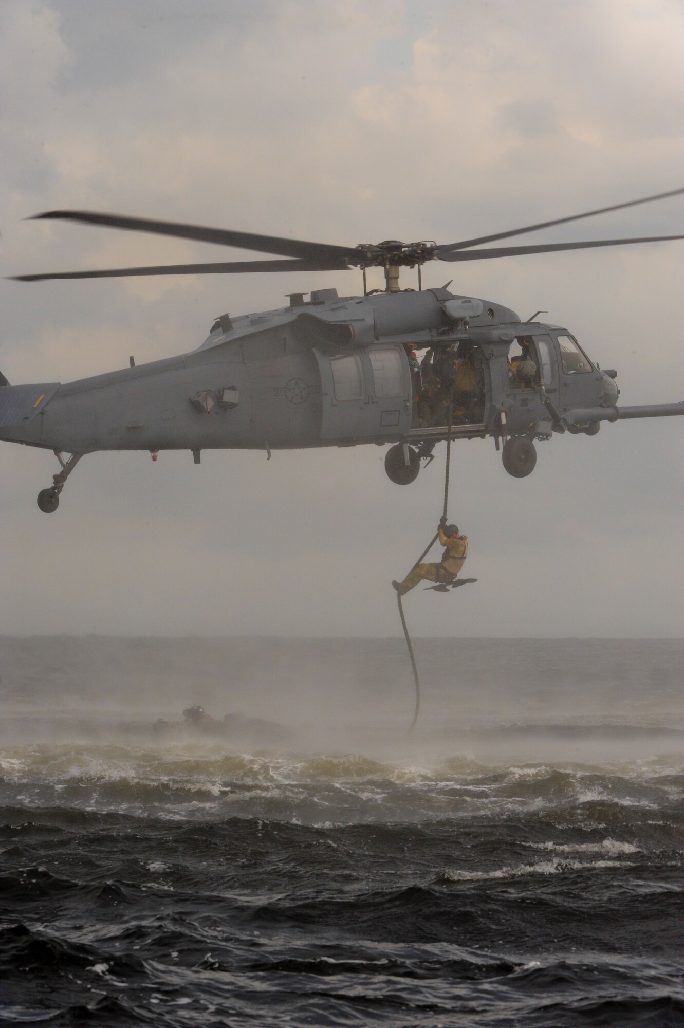 A pararescueman from the 38th Rescue Squadron, Moody Air Force Base, Ga., drops into the Gulf of Mexico during a water rescue exercise Aug. 14, 2012. During the exercise, pararescuemen had to locate downed victims several miles apart and provide self aid buddy care as needed. (U.S. Air Force photo by Staff Sgt. Joshua J. Garcia/Released)