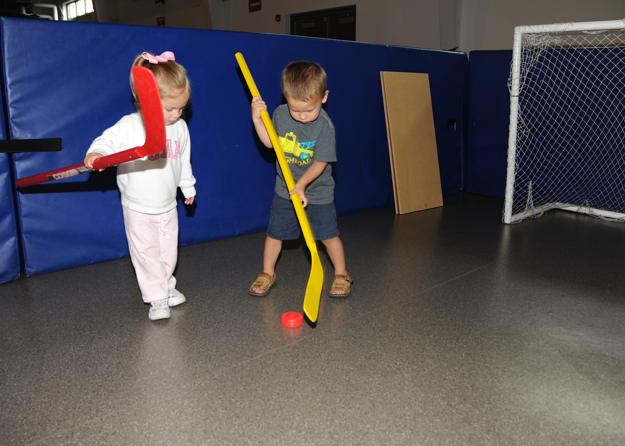 Emily Scarbrough, 2, plays hockey with J. J. Troyer, 2, at the Exceptional Family Member Program Family Event, Aug. 15, 2012, on Grand Forks Air Force Base, N. D. The event was held to raise awareness of the different opportunities that the EFMP offers.  The mission of the EFMP is to improve the quality of life of families that support a family member with a special need. The event was made possible in part by a grant from the Air Force Aid Society. (U.S. Air Force photo/Airman 1st Class Ashley N. Taylor)
