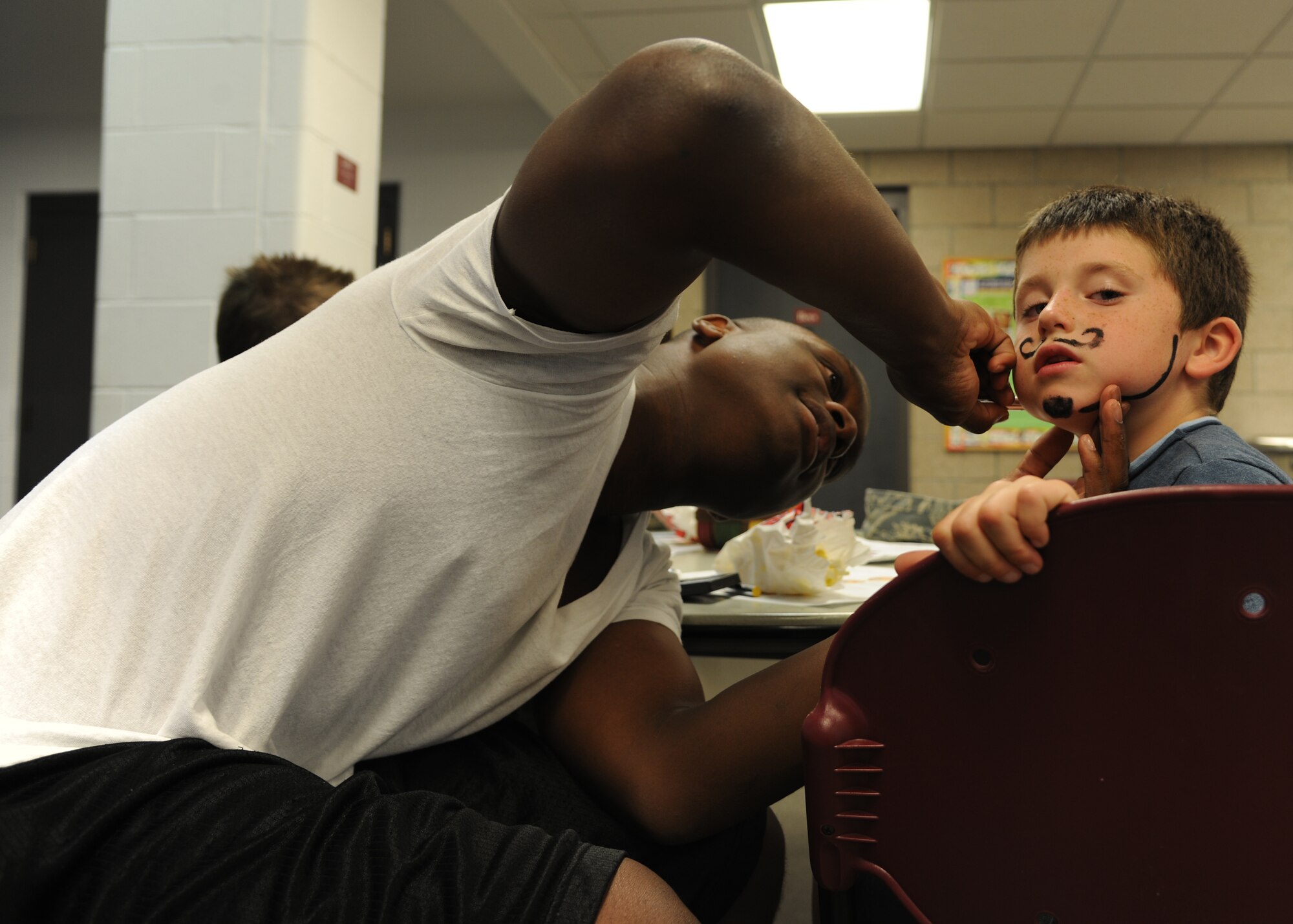 Ben White, 6, gets his face painted by Airman Henry Taylor III, 319th Comptroller Squadron, at the Exceptional Family Member Program Family Event, Aug. 15, 2012, on Grand Forks Air Force Base, N. D. The event was held to raise awareness of the different opportunities that the EFMP offers.  The mission of the EFMP is to improve the quality of life of families that support a family member with a special need. The event was made possible in part by a grant from the Air Force Aid Society. (U.S. Air Force photo/Airman 1st Class Ashley N. Taylor)