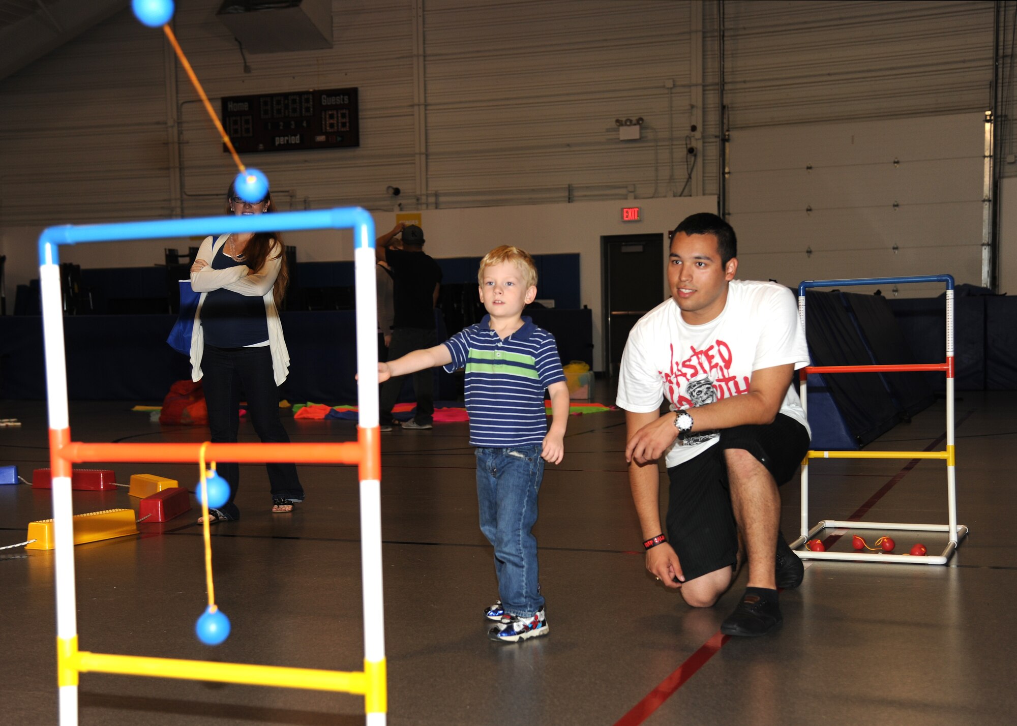 Jaden Spencer, 4, throws a bola in a game of ladder ball with Airman 1st Class Edward Echevarria, 69th Maintenance Squadron, at the Exceptional Family Member Program Family Event, Aug. 15, 2012, on Grand Forks Air Force Base, N. D. The event was held to raise awareness of the different opportunities that the EFMP offers.  The mission of the EFMP is to improve the quality of life of families that support a family member with a special need. The event was made possible in part by a grant from the Air Force Aid Society. (U.S. Air Force photo/Airman 1st Class Ashley N. Taylor)