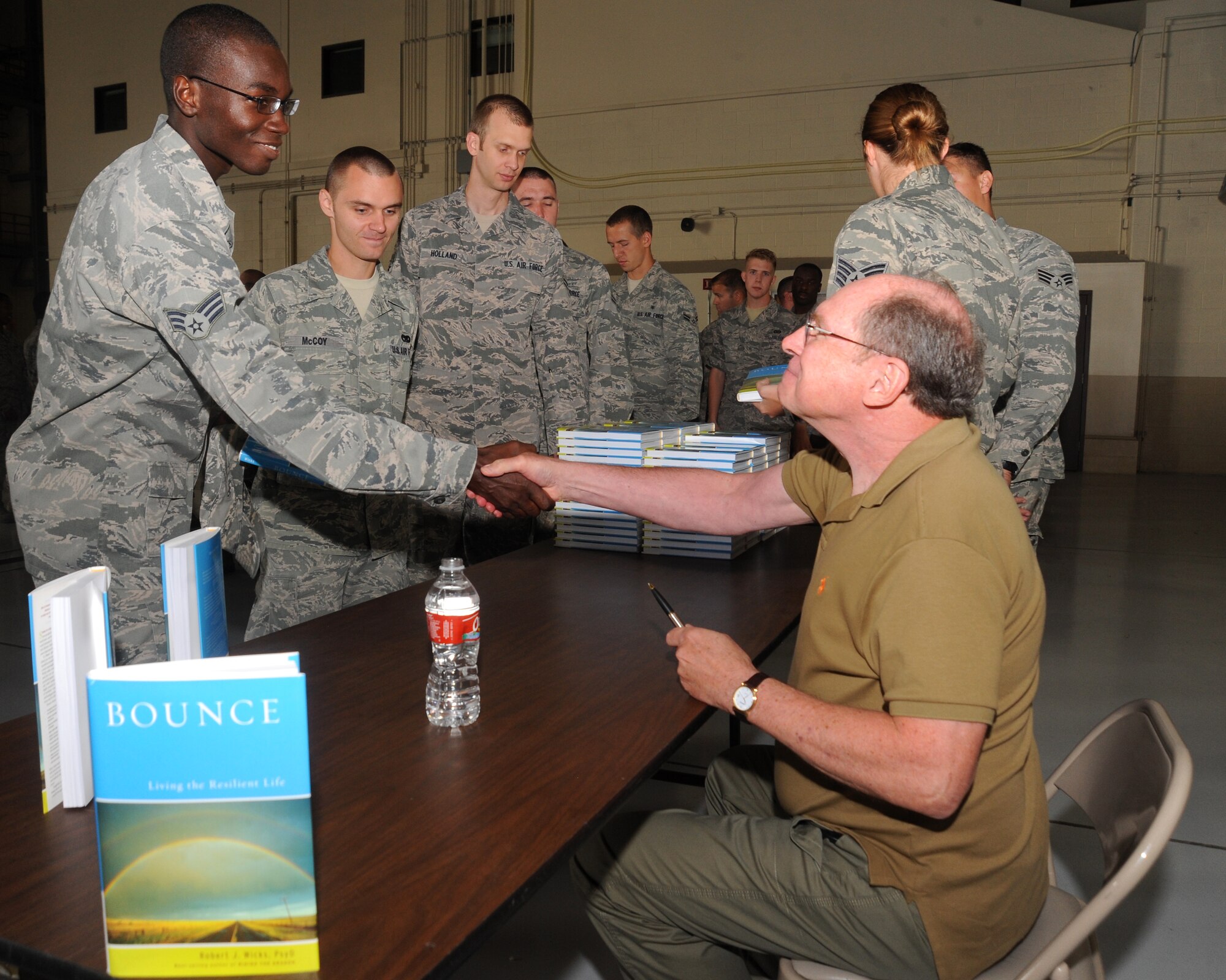 Dr. Robert Wicks, a psychologist and author, shakes hands with Senior Airman Ollor Obarjima on Aug. 15 2012, on Grand Forks Air Force Base, N.D. Wicks signed copies of his book “Bounce: Leading the Resilient Life” after speaking to Airmen during the wing’s Resiliency Day.    (U.S. Air Force photo/ Airman 1st Class Xavier Navarro)