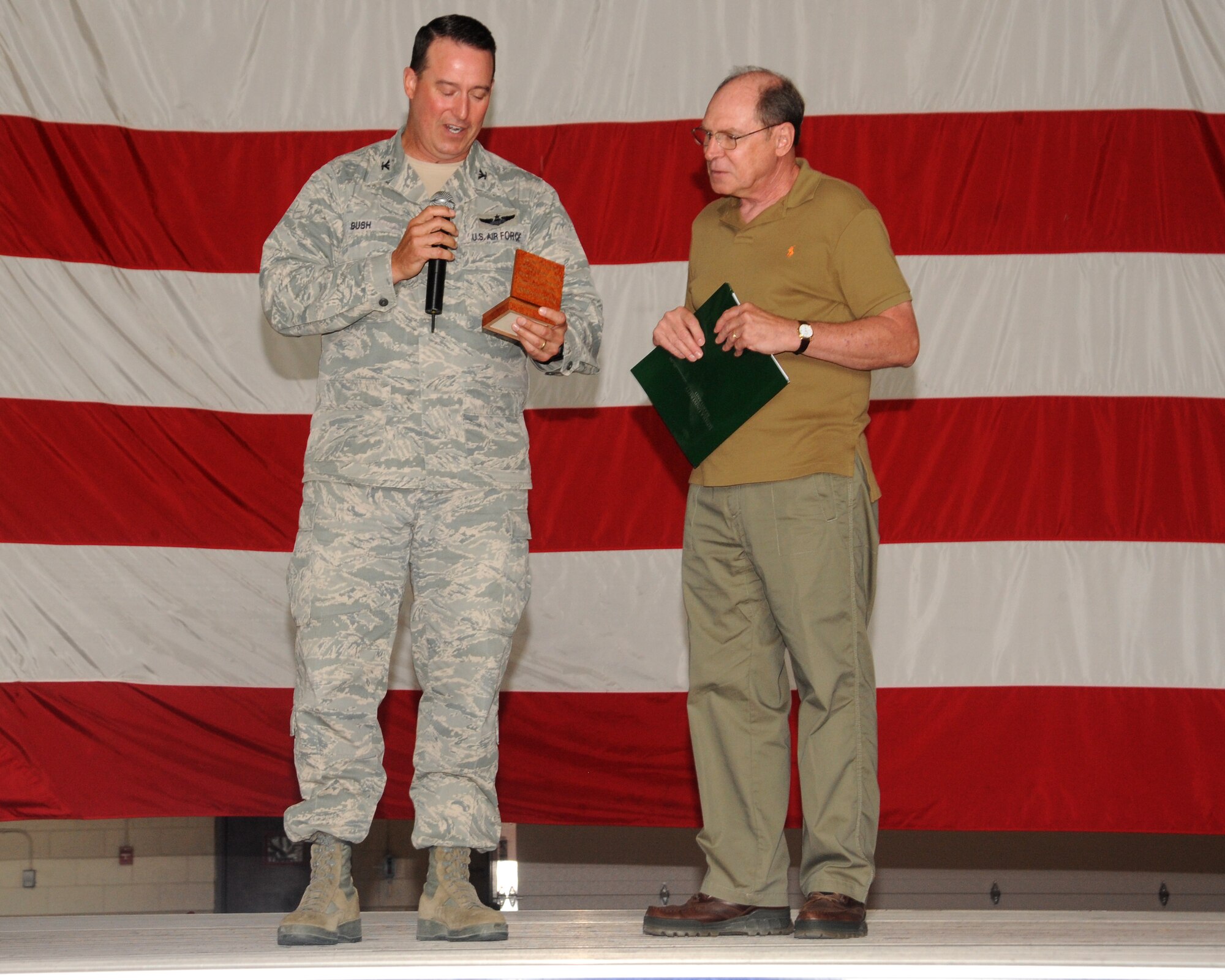 Col. Tim Bush, 319th Air Base Wing commander, gives a commander’s coin to Dr. Robert Wicks on Aug. 15 2012, on Grand Forks Air Force Base, N.D. Wicks, a psychologist and author, spoke to Airmen during the wing’s Resiliency Day.  (U.S. Air Force photo/ Airman 1st Class Xavier Navarro)