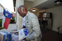 Maj. Gen. Alfred Stewart, Air Force Personnel Center commander, piles a large bag of rice on a Feds Feed Families food bank donation barrel at a collection event held at AFPC on Joint Base San Antonio-Randolph, Texas, Aug. 15. (U.S. Air Force photo by Rich McFadden) 