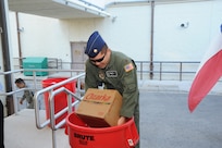 Maj. David Kaya, Air Force Personnel Center Commander Action Group action officer, places a case of water in a Feds Feed Families food bank donation barrel at a collection event held at AFPC on Joint Base San Antonio-Randolph, Texas, Aug. 15. (U.S. Air Force photo by Rich McFadden) 