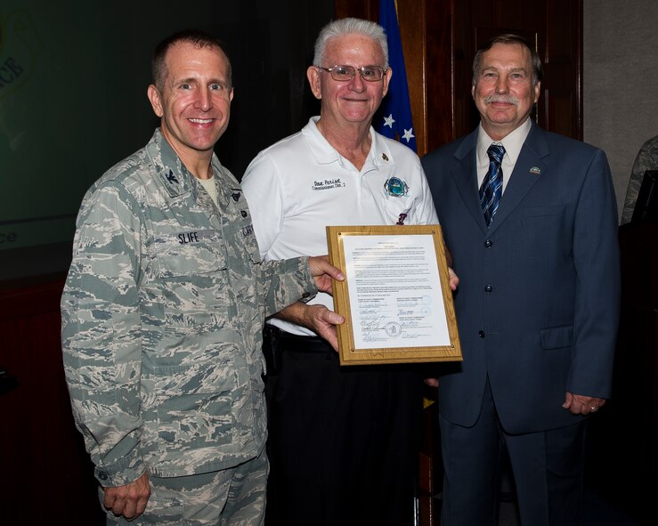 U.S. Air Force Col. Jim Slife, commander of 1st Special Operations Wing, receives a plaque from Dave Parisot, a commissioner of Okaloosa County (middle) and Robert Cole, a commissioner of Santa Rosa County (right), during a ceremony at wing headquarters on Hurlburt Field, Fla., Aug. 15, 2012. Okaloosa and Santa Rosa Counties are partnering up with Curry and Roosevelt Counties near Cannon Air Force Base, N.M., to bolster support to Air Force Special Operations Command Airmen and their families in both areas. (U.S. Air Force Photo/Airman 1st Class Christopher Williams)(