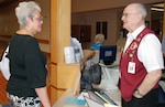Volunteer information desk greeter Ed O'Boyle helps a vistor to San Antonio Military Medical Center navigate the hospital. Greeters are often the first person a patient, family member, vistor or vendor meets. (Photo by Mike Dulevitz, Brooke Army Medical Center Volunteer Services)