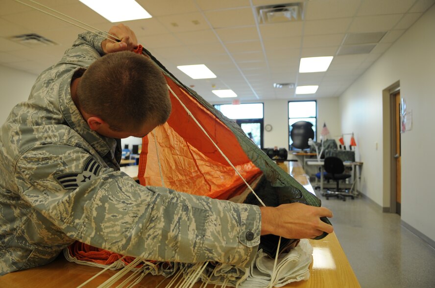 U.S. Air Force Senior Airman Colton Brown, 4th Operations Support Squadron aircrew flight equipment specialist, performs a line continuity check on an avanced concept ejection system II parachute at the parachute shop on Seymour Johnson Air Force Base, N.C., Aug. 14, 2012. The line continuity check is performed everytime a parachute is packed to make sure no lines are crossed, hindering the chutes deployment and potentially causing serious injury or death to an aircrew member. (U.S. Air Force photo/Airman 1st Class Aubrey Robinson)