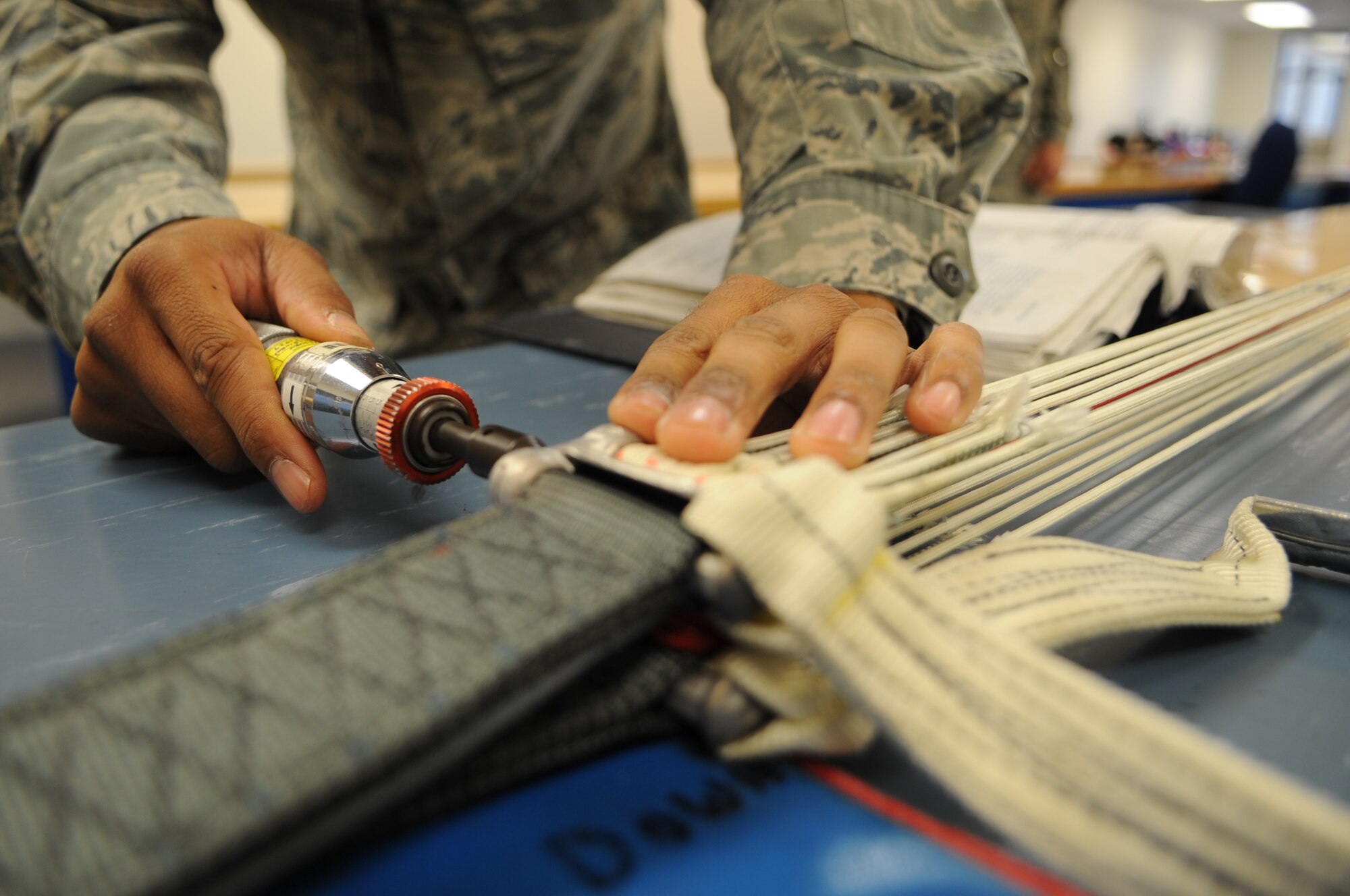 U.S. Air Force Senior Airman Kendric Skinner, 4th Operations Support Squadron aircrew flight equipment specialist, torques the connector link on an advanced concept ejection system II parachute at the parachute shop on Seymour Johnson Air Force Base, N.C., Aug. 14, 2012. The connector link holds lines from the ACES II parachute to the aircrew member and releases the lines when in contact with water to prevent the aircrew member from entanglement. (U.S. Air Force photo/Airman 1st Class Aubrey Robinson)