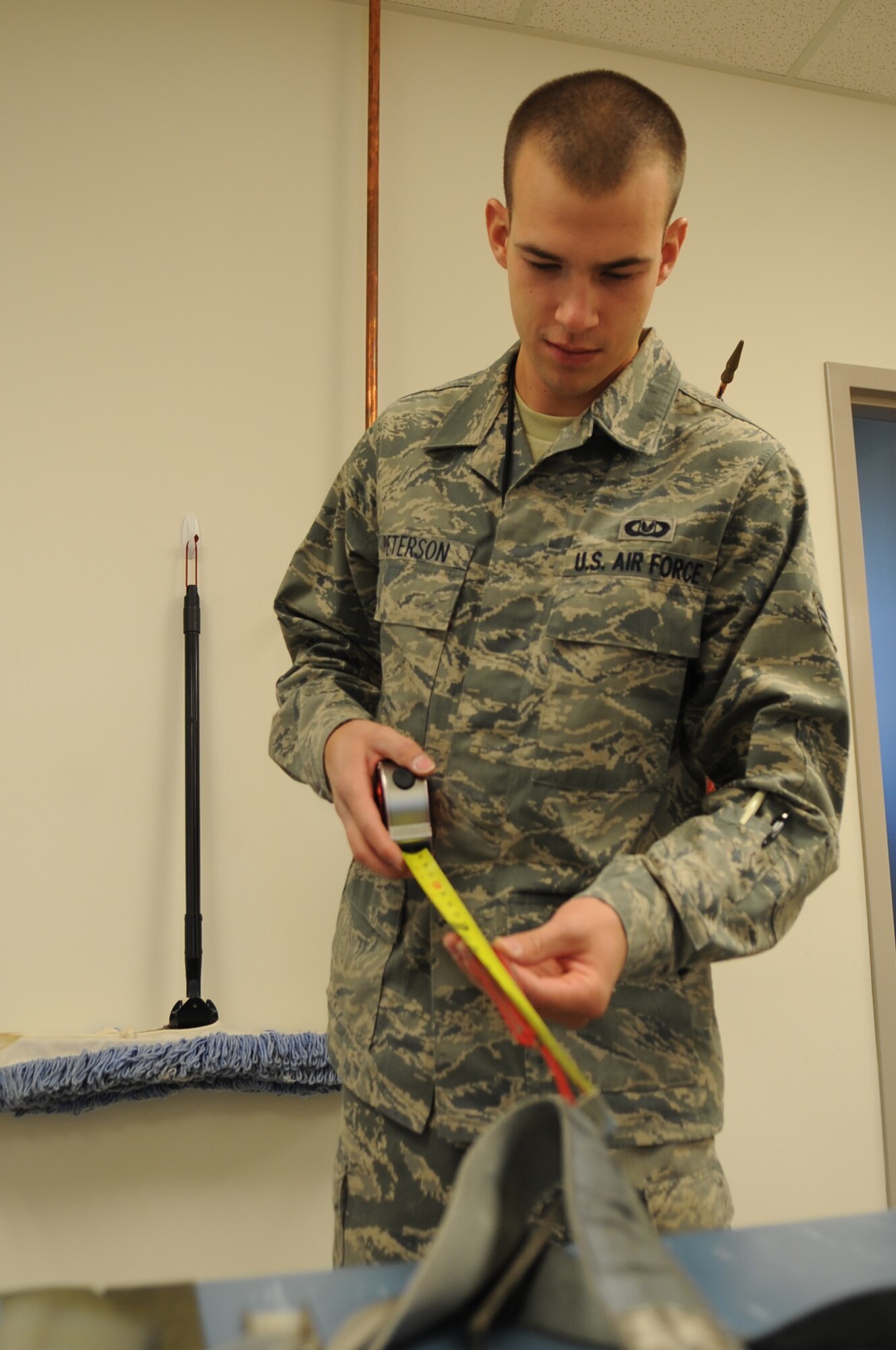 U.S. Air Force Senior Airman Mark Peterson, 4th Operations Support Squadron aircrew flight equipment specialist, measures the length of the foreline on an advanced concept ejection system II parachute at the parachute shop on Seymour Johnson Air Force Base, N.C., Aug. 14, 2012. The forelines on the ACES II parachute are used to guide the aircrew member to the ground after egressing an aircraft and must measure between 9.5 and 11.5 inches. (U.S. Air Force photo/Airman 1st Class Aubrey Robinson)