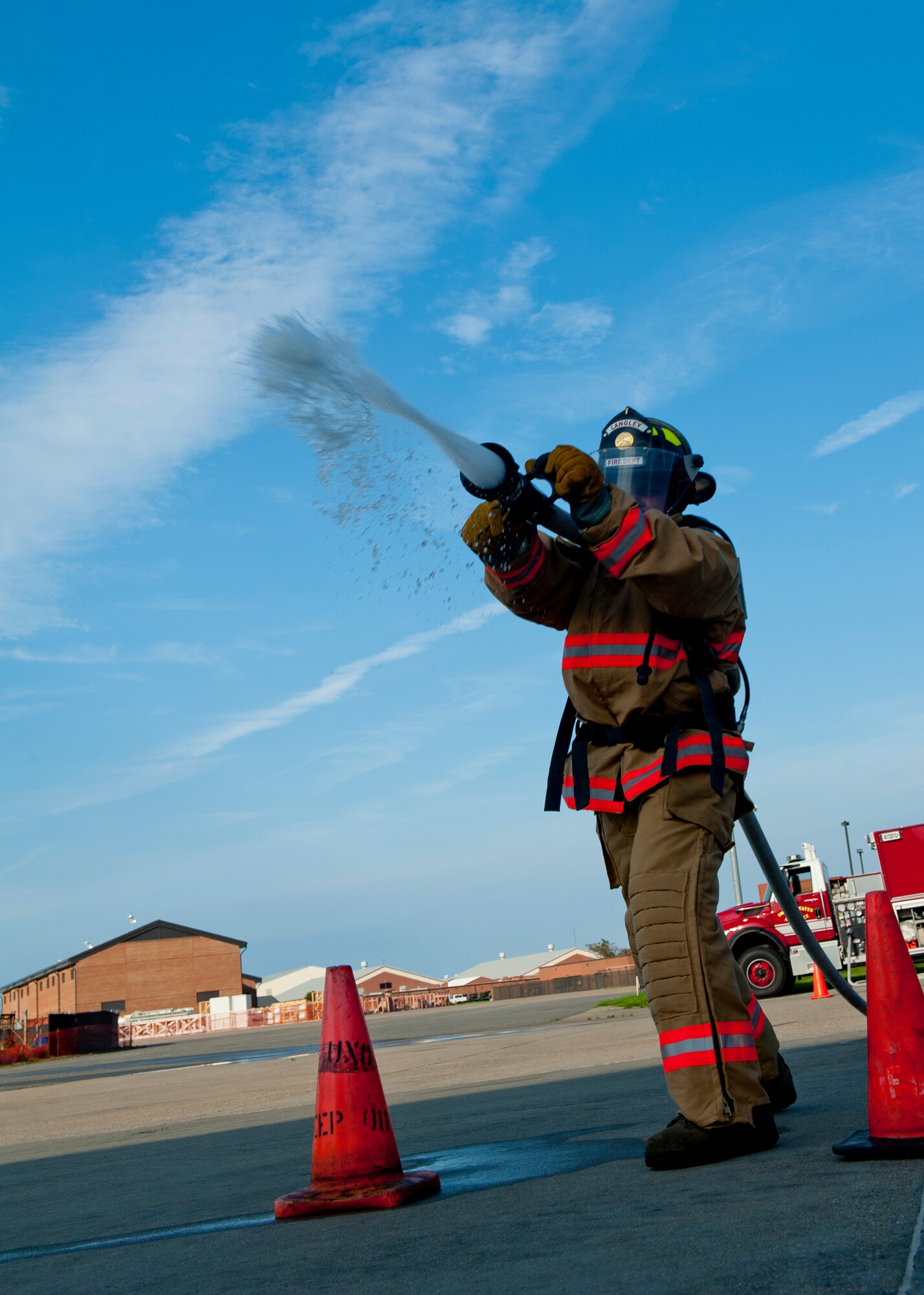 Airman 1st Class Chrisili Villasenor, 633rd Civil Engineer Squadron firefighter, fires a hose at the end of his section of the medley practice, Aug. 14, 2012, at Langley Air Force Base, Va. The world record in the Firefighter Combat Challenge team-medley is one minute and seven seconds. (U.S. Air Force photo by Airman 1st Class R. Alex Durbin/Released)