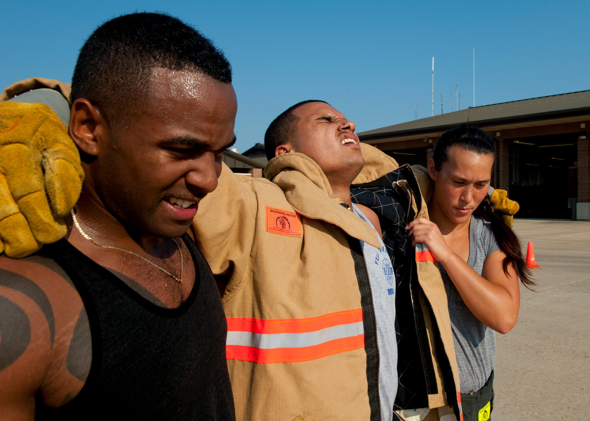 Airman 1st Class Bruce Lovett and Staff Sgt. Kira Enlow, 633rd Civil Engineer Squadron firefighters, aid their tired team-mate, Airman 1st Class Chrisili Villasenor, after a long practice, Aug. 13, 2012, at Langley Air Force Base, Va. The Firefighter Combat Challenge seeks to encourage firefighter fitness and demonstrate the rigors of the profession. (U.S. Air Force photo by Senior Airman John Strong/Released)