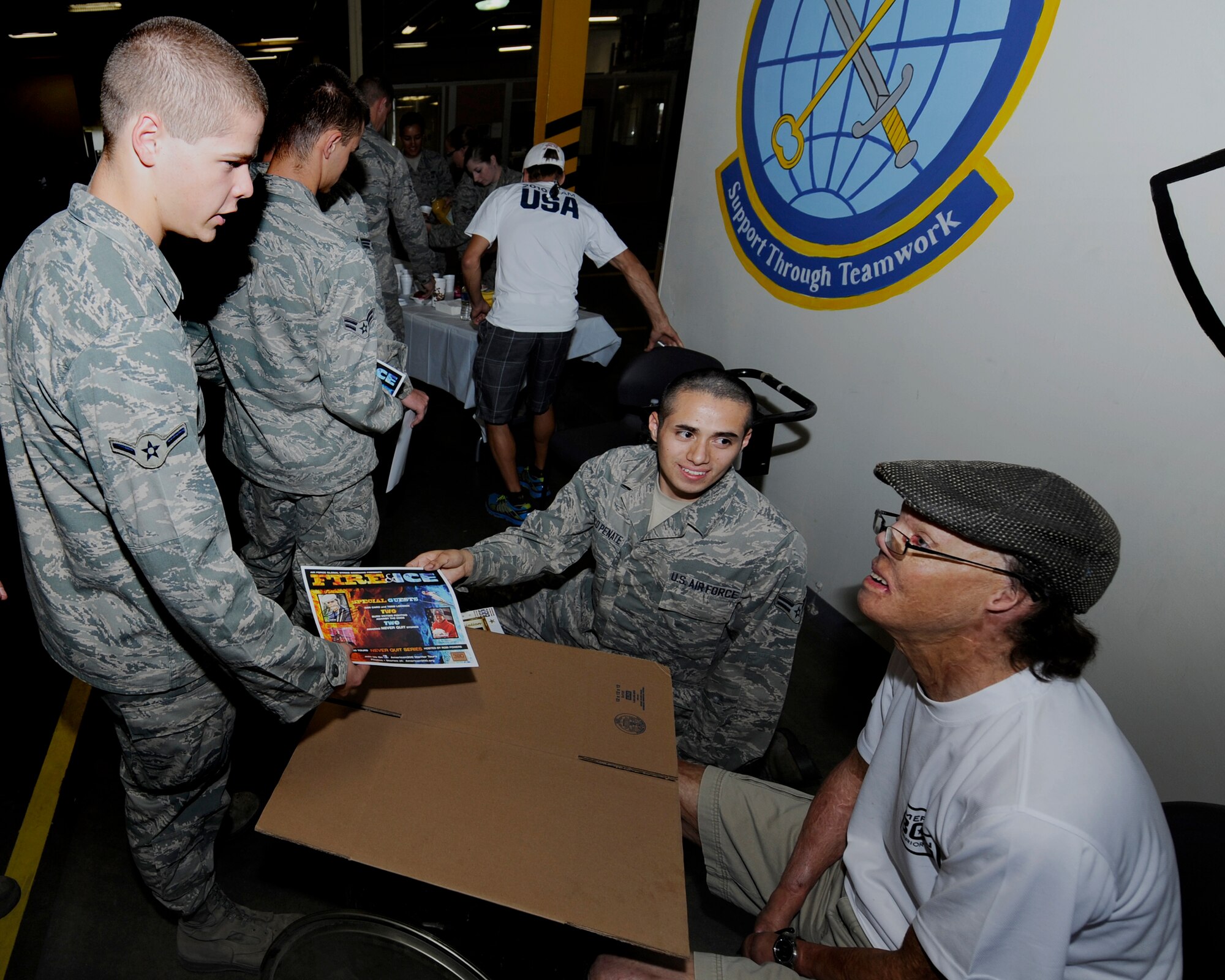 MINOT AIR FORCE BASE, N.D. -- Dan Caro, American300 Warrior Tours Fire and Ice tour member, signs autographs for Airmen and personnel from the 5th Logistics Readiness Squadron assisted by Airman 1st Class Wilbur Velasco, 5th LRS vehicle operator here Aug. 7. The tour gave Caro the opportunity to share his story with base Airmen, and also to encourage them to keep fighting for the things that matter most to them no matter what the odds. "It really touched my when they (the tour members) spoke about overcoming your past" Velesco said with a smile, "it inspired me to be stronger."  (U.S Air Force photo/Airman 1st Class Stephanie Ashley)
