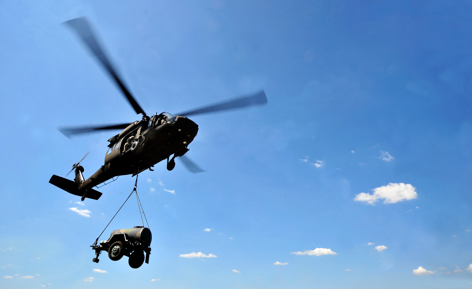 The Illinois National Guard uses a UH-60 Blackhawk helicopter to lift a sling loaded water buffalo during training on Scott Air Force Base, Ill. Aug. 11, 2012. The U.S. Transportation Command's Joint Transportation Reserve Unit, held this training for Air Force, Army, Navy and Department of Homeland Security personnel to learn about sling load and medical evacuation in the event of a natural disaster or emergency were to occur in this area. This is the first time the training has taken place on Scott. (U.S. Air Force photos/ Staff Sgt. Stephenie Wade)