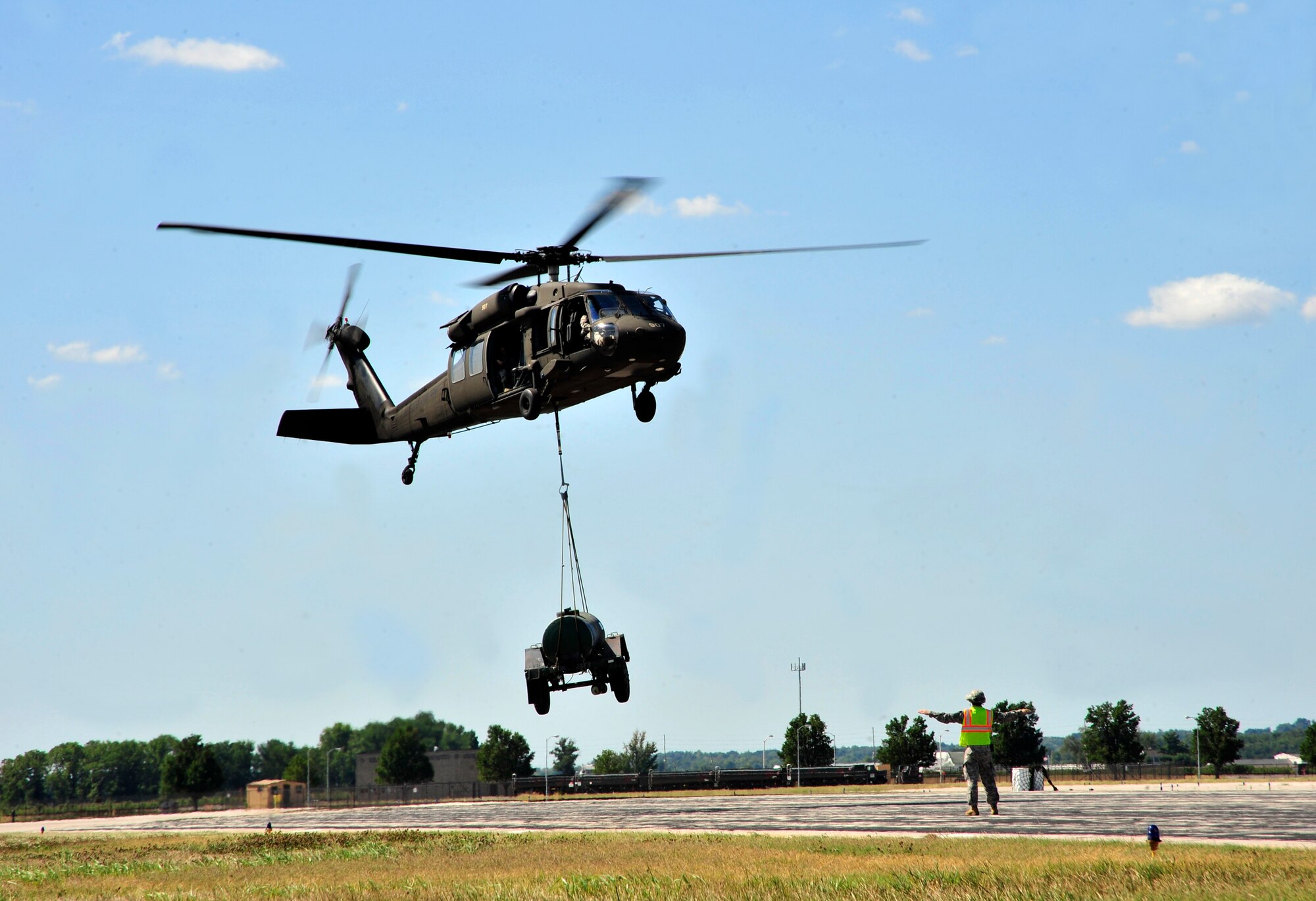 The Illinois National Guard uses a UH-60 Blackhawk helicopter to lift a sling loaded water buffalo during training on Scott Air Force Base, Ill. Aug. 11, 2012. The U.S. Transportation Command's Joint Transportation Reserve Unit, held this training for Air Force, Army, Navy and Department of Homeland Security personnel to learn about sling load and medical evacuation in the event of a natural disaster or emergency were to occur in this area. This is the first time the training has taken place on Scott. (U.S. Air Force photos/ Staff Sgt. Stephenie Wade)